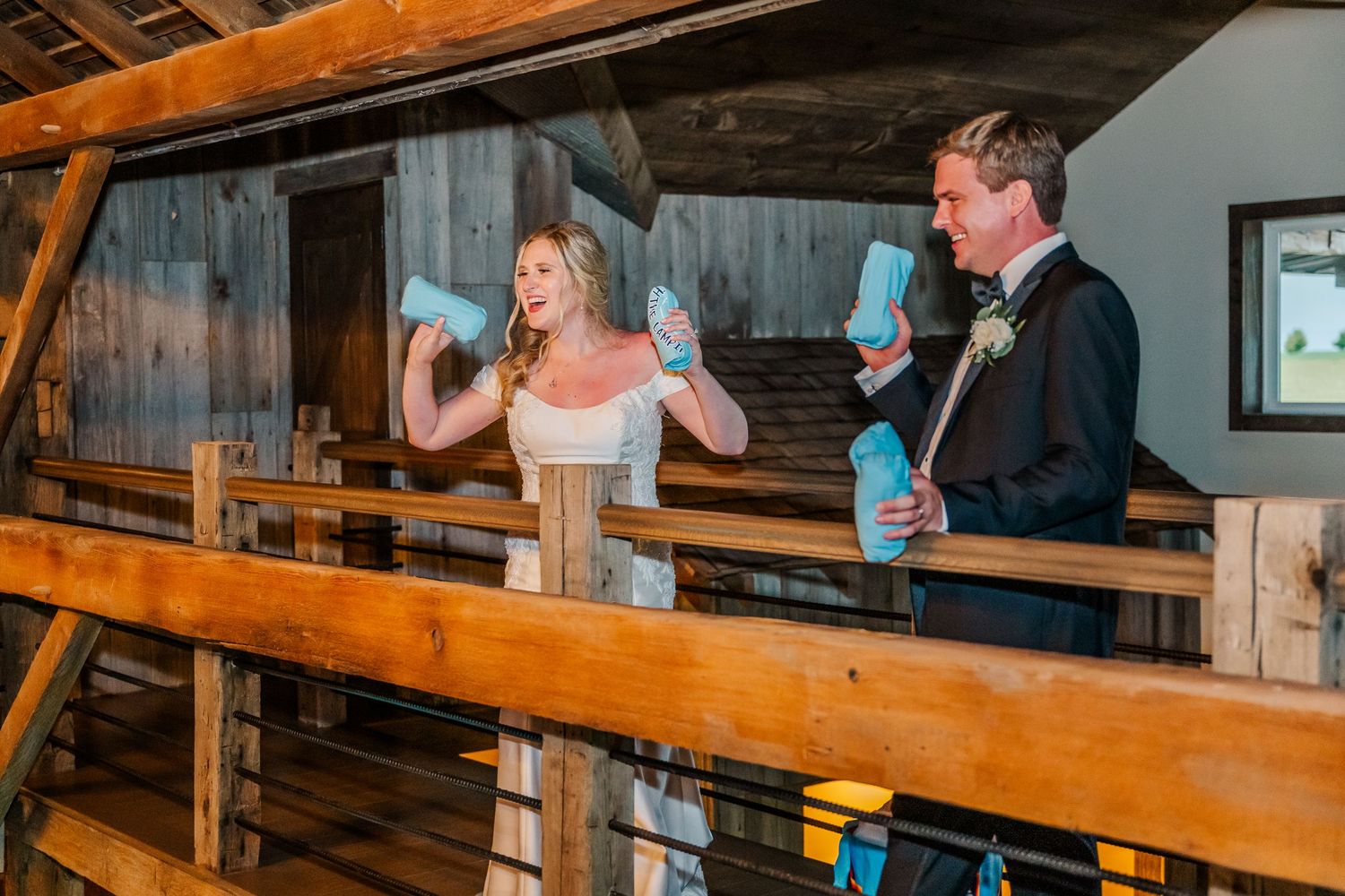 Couple enjoying drinks and laughing together at a rustic wooden bar.
