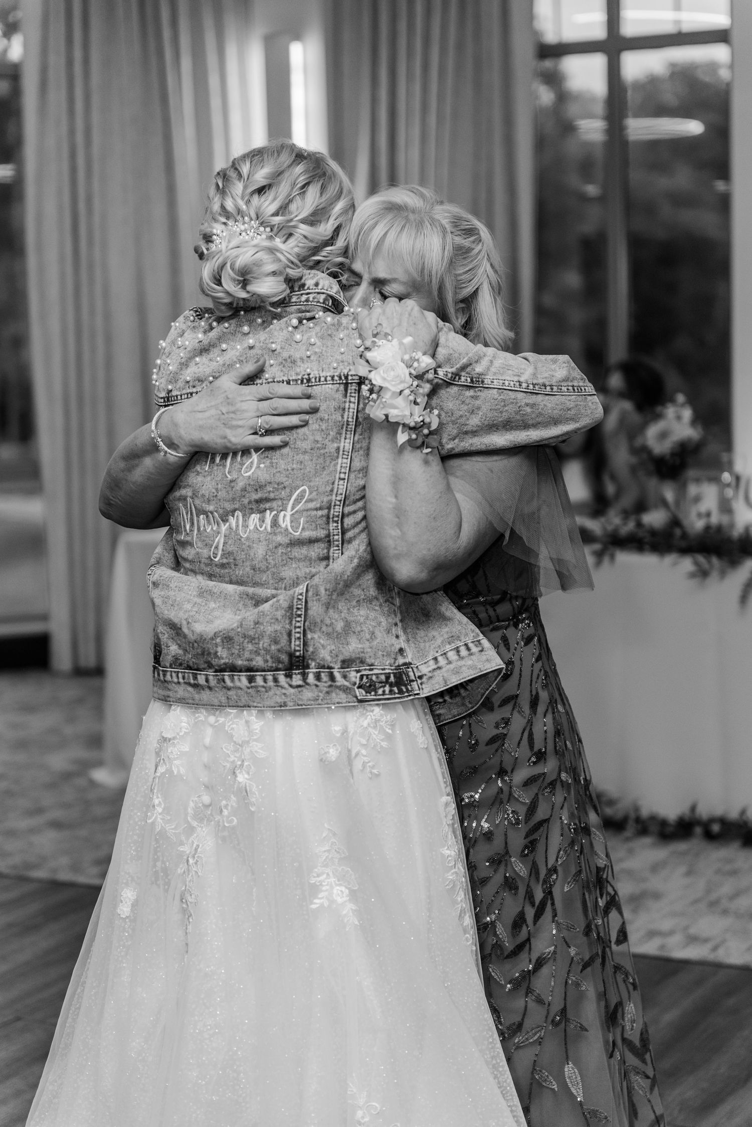 Close-up details of denim jackets with embroidery and decorative elements at a wedding celebration.