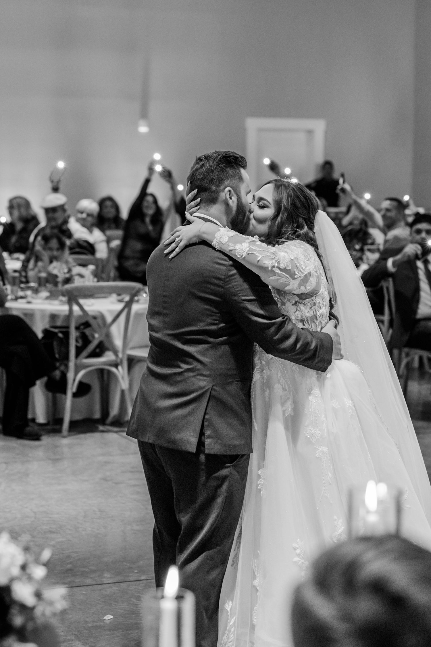 A couple shares their first dance as wedding guests hold sparklers in the background during the reception. Four Seasons Barn Wedding