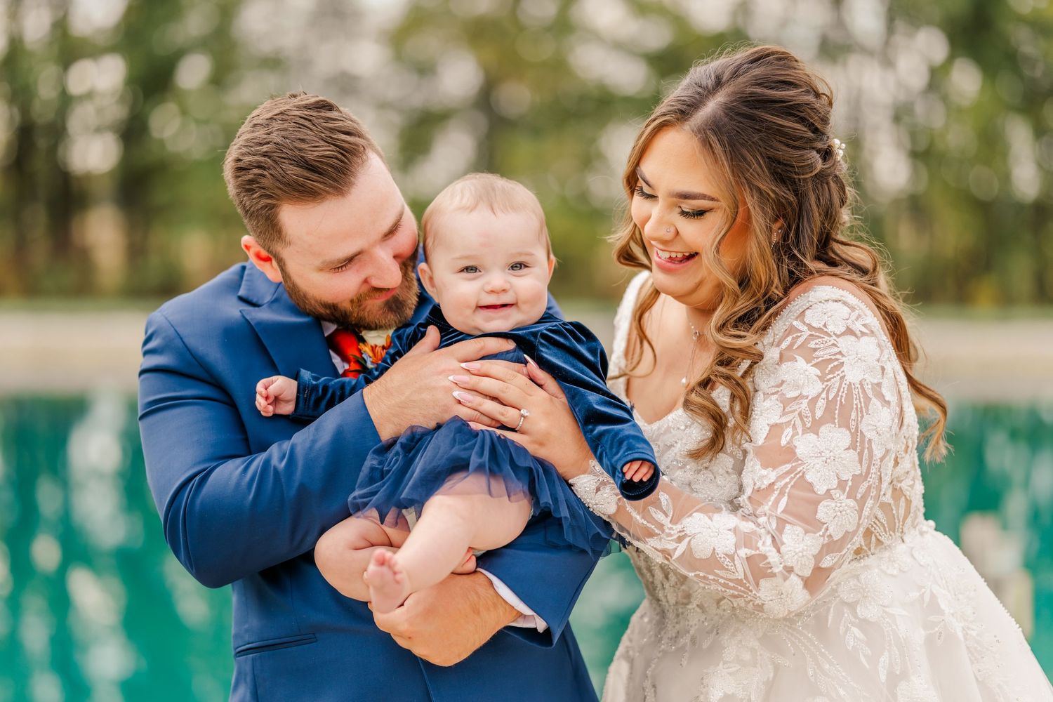 A loving family shares joyful moments together in an outdoor photo session with natural greenery in the background.