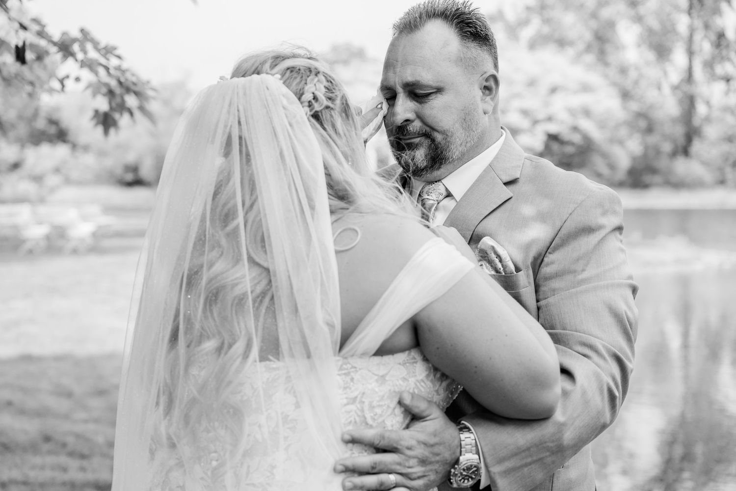 A romantic black and white photo series captures tender moments between newlyweds during their outdoor wedding celebration.