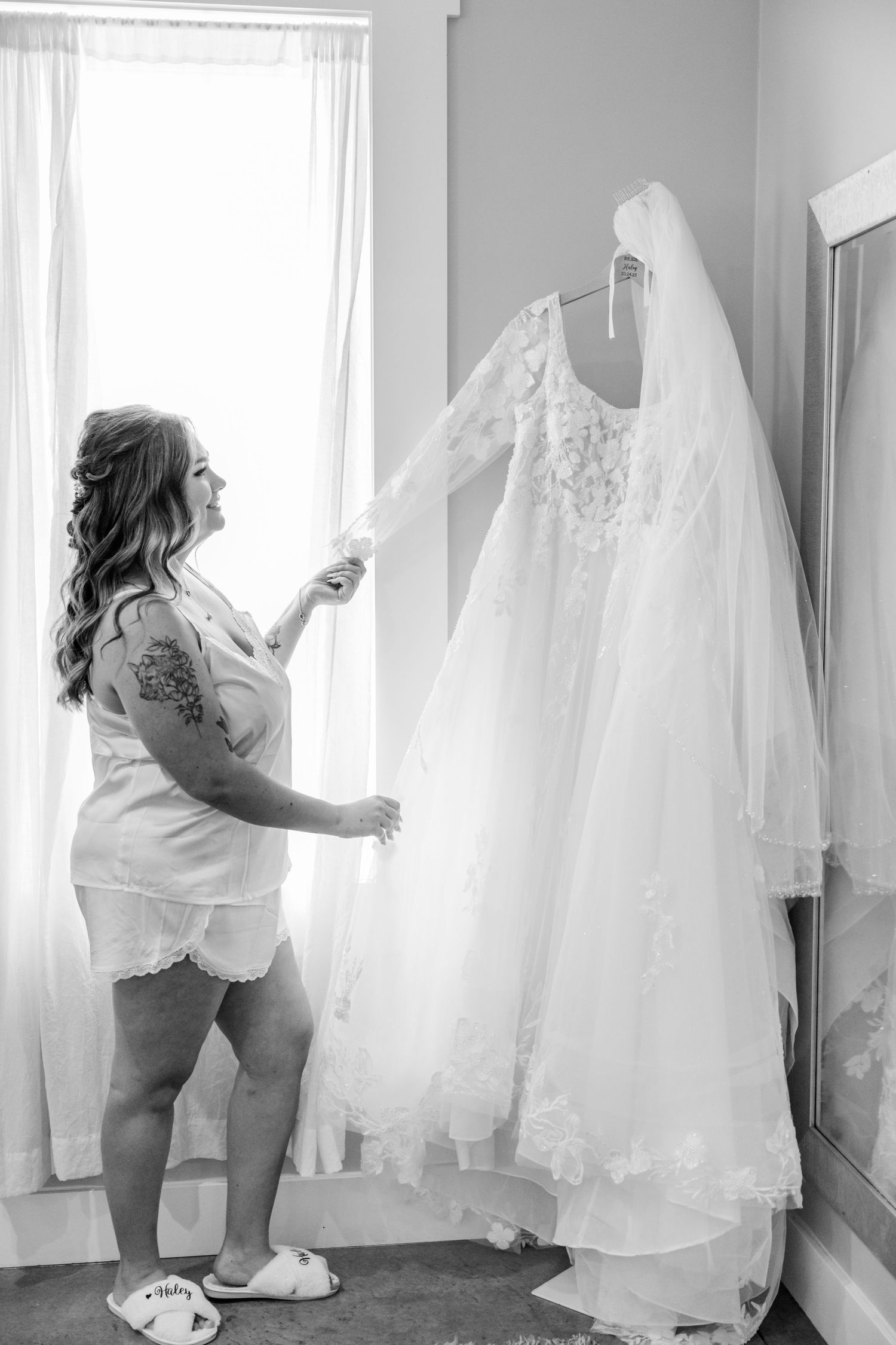 Black and white photo series showing a toddler exploring and playing with wedding dresses hanging in a room.