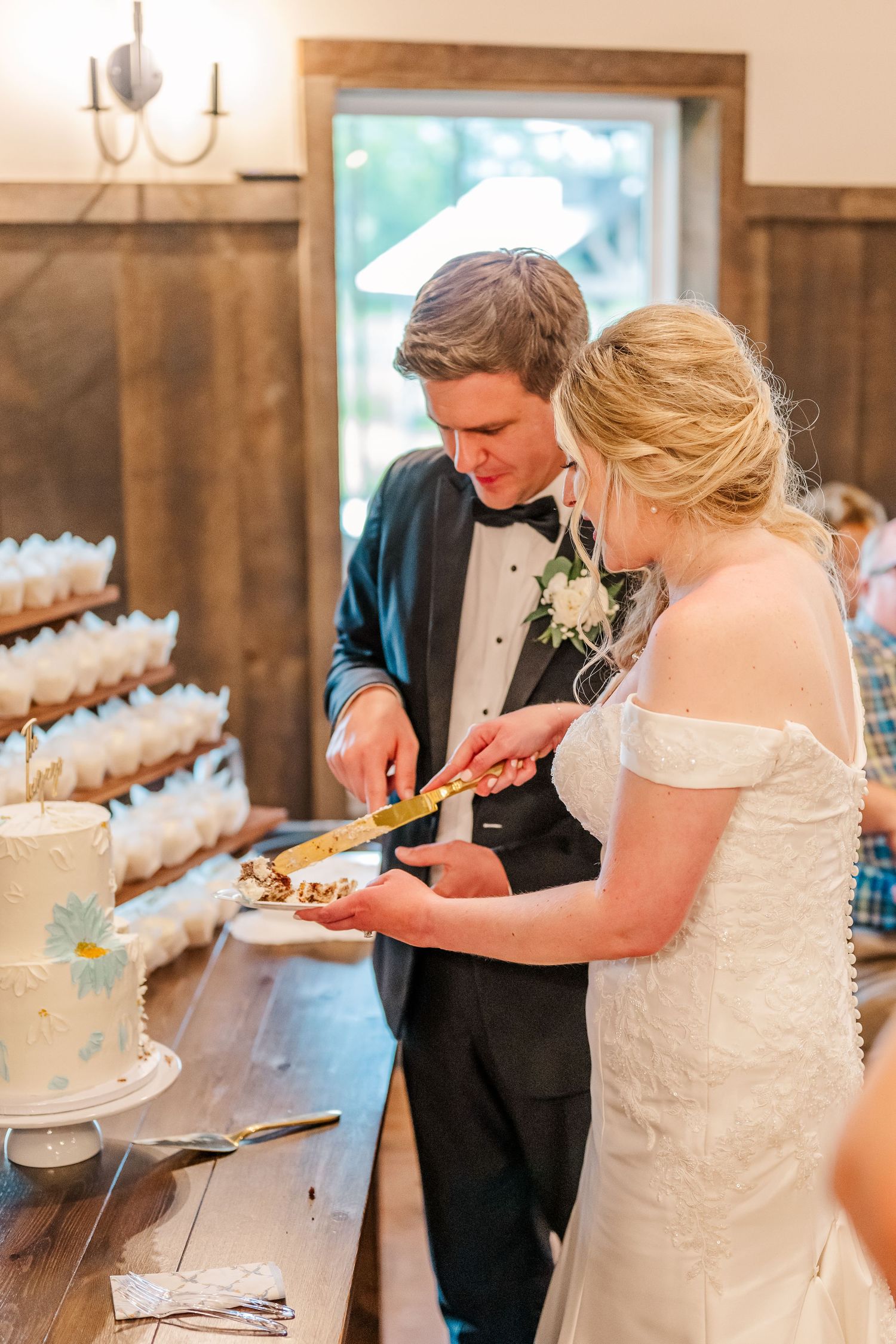 Wedding couple serving food at an elegant buffet table during their reception celebration. The Old Barns at Dry Run Farms in Williamsport