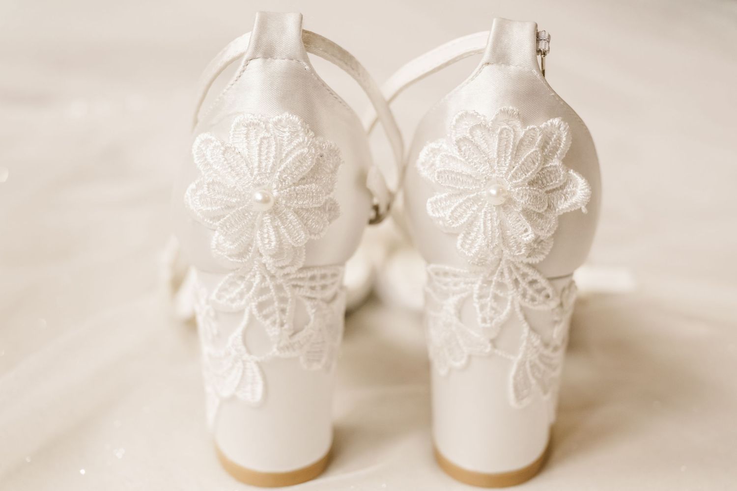 White ceramic butterfly-shaped decorative objects arranged in a row against a light neutral background.