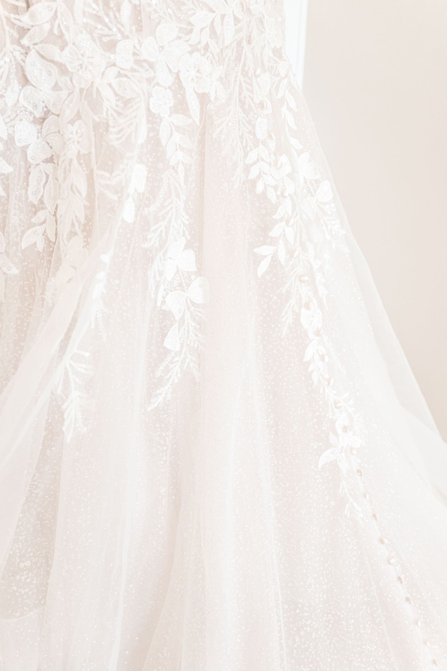 A collection of elegant white wedding dresses hanging on display in a bridal boutique.