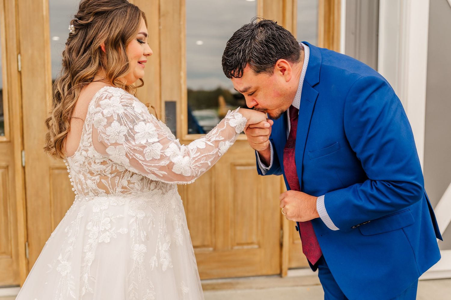 A couple shares an intimate moment during their wedding ceremony, with the groom in a royal blue suit.