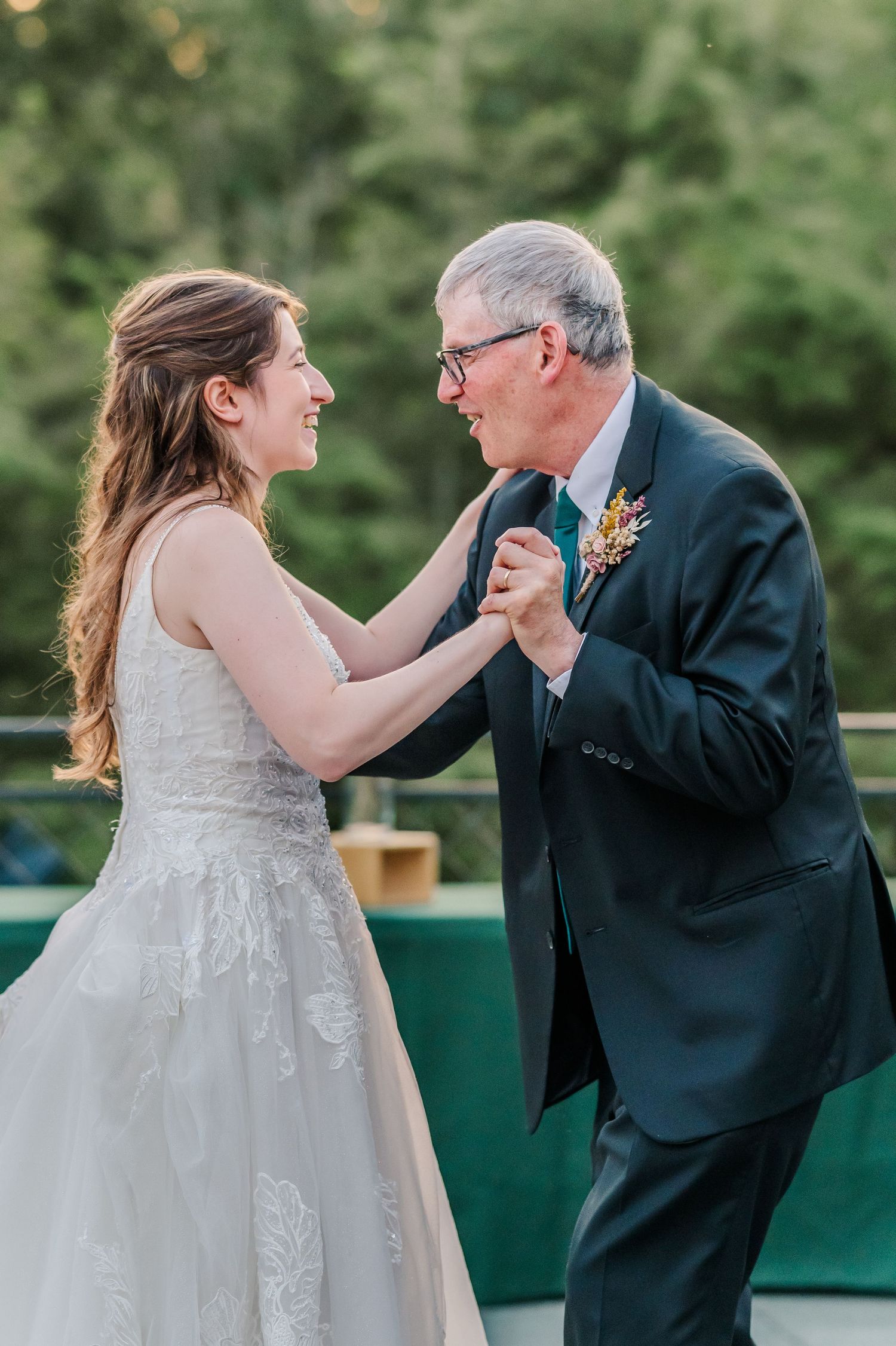 A tender moment shared during a wedding dance outdoors.