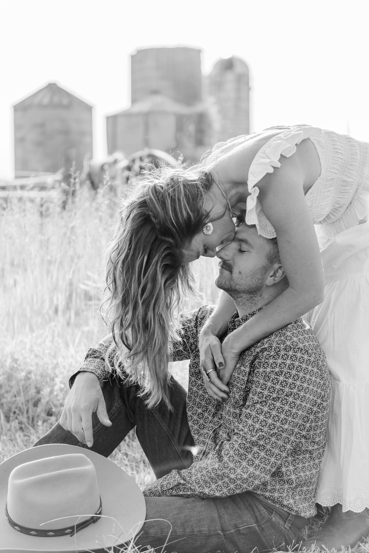 Romantic black and white photo series of a couple sharing intimate moments in a rustic outdoor setting.