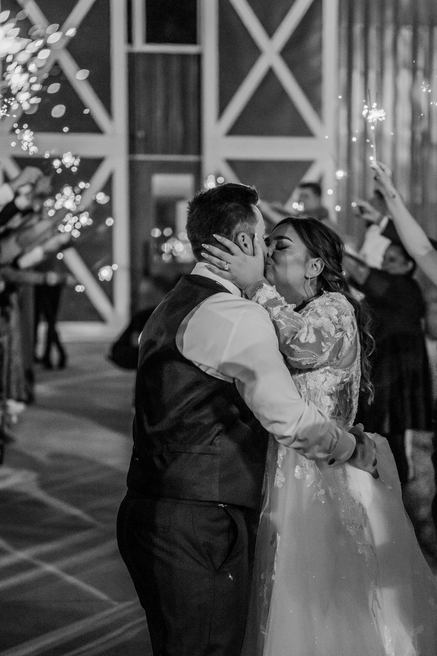 Romantic dance moment captured in black and white under twinkling lights at an indoor venue.Four Seasons Barn Wedding & Event Venue