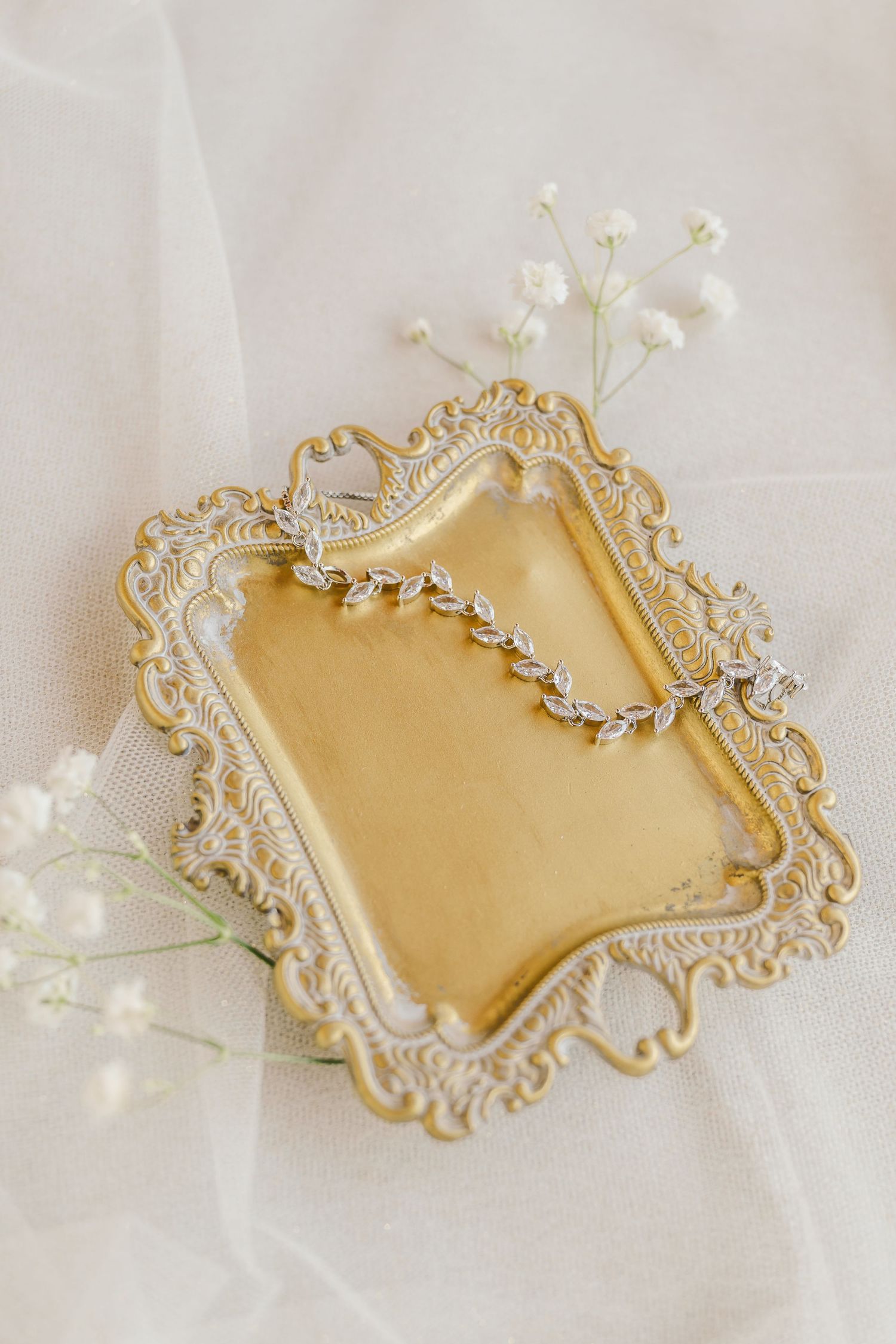 Elegant gold and white decorative vintage frames with ornate baroque details arranged in a series against soft fabric.