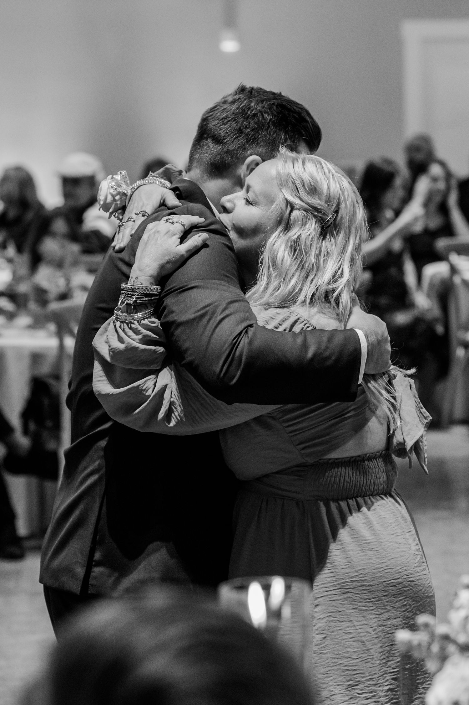 A romantic black and white dance scene shows a couple sharing a tender kiss while embracing on the dance floor.