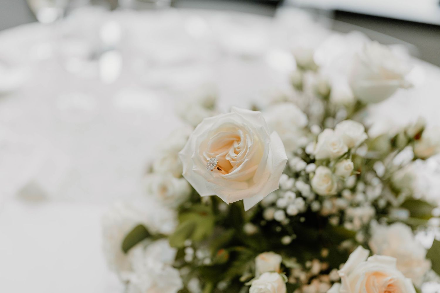 Delicate arrangement of peach roses and baby's breath flowers in soft focus.