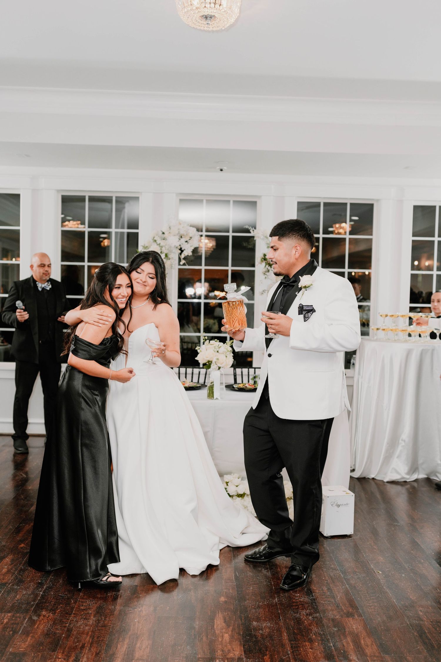 Wedding guests dancing and celebrating on a polished wooden dance floor.