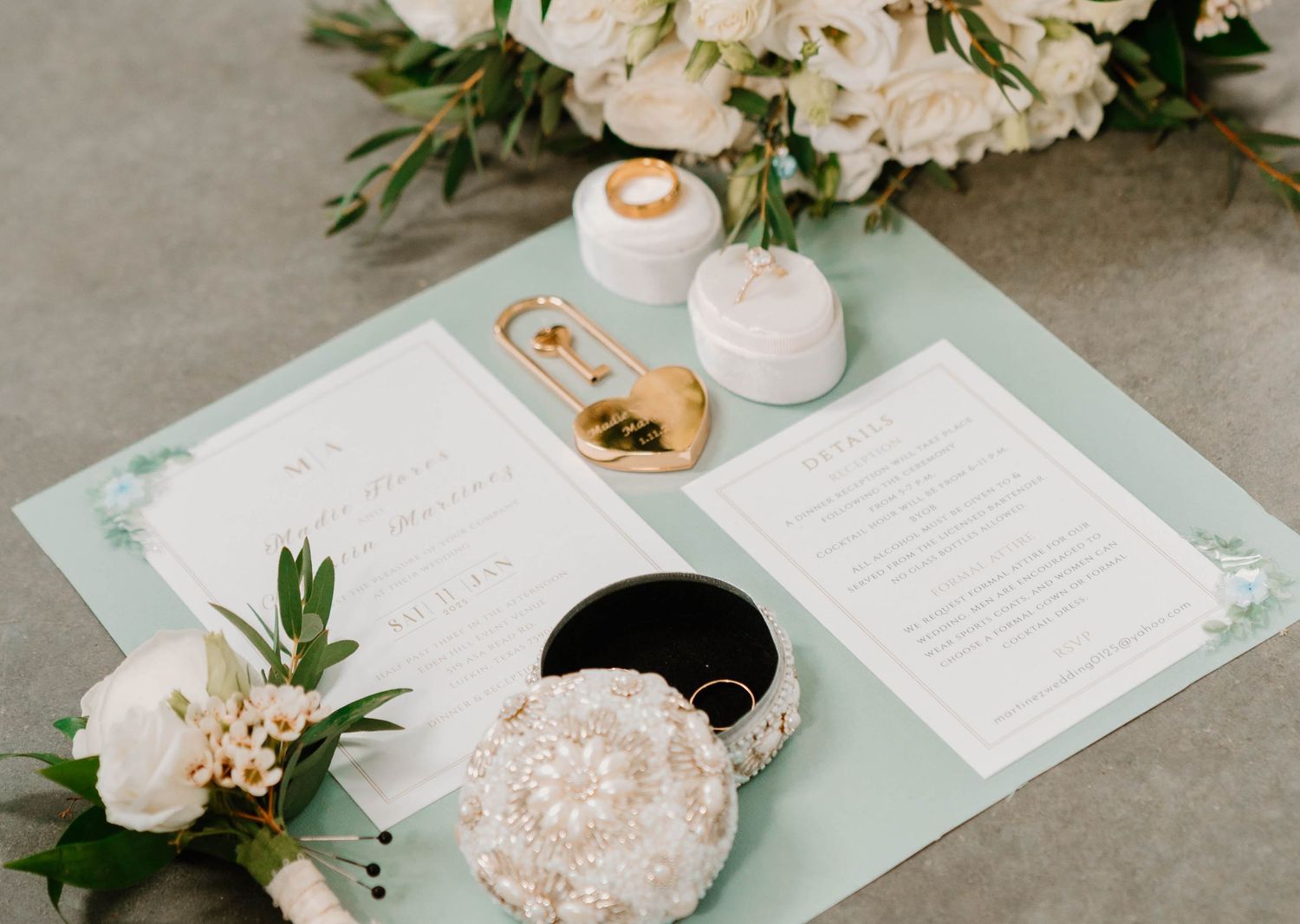 Wedding invitations and floral arrangements displayed on a light gray surface.