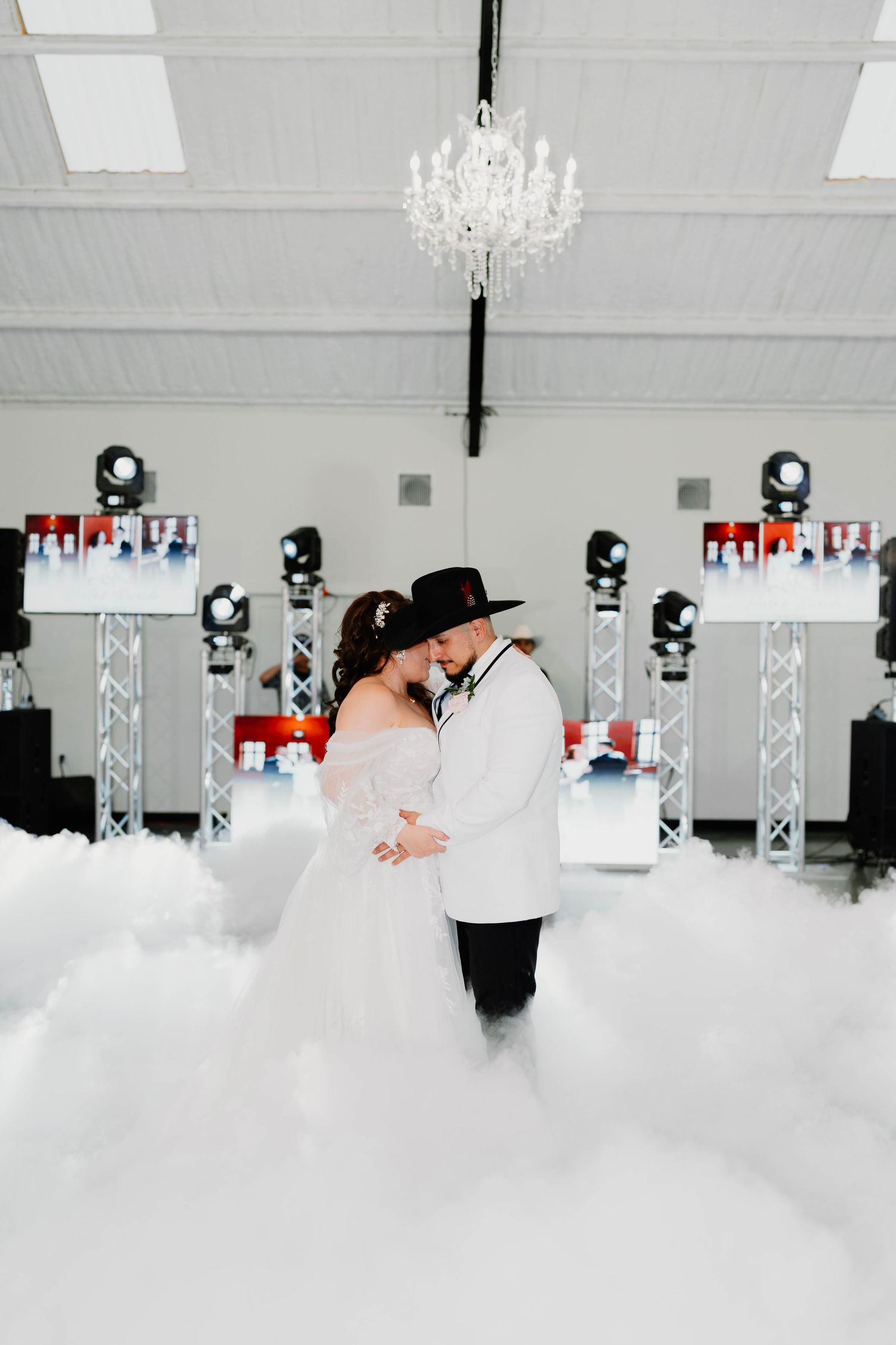 Couple dances in fog during their first dance at an indoor wedding reception.