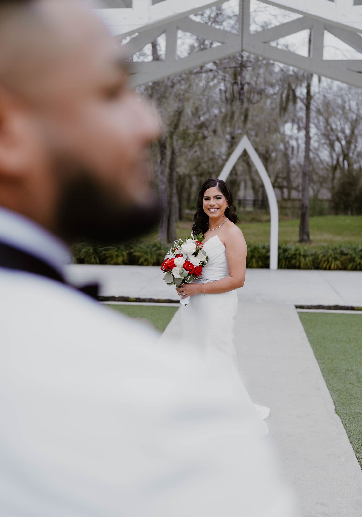 Wedding celebration under a white outdoor pavilion with decorative florals.