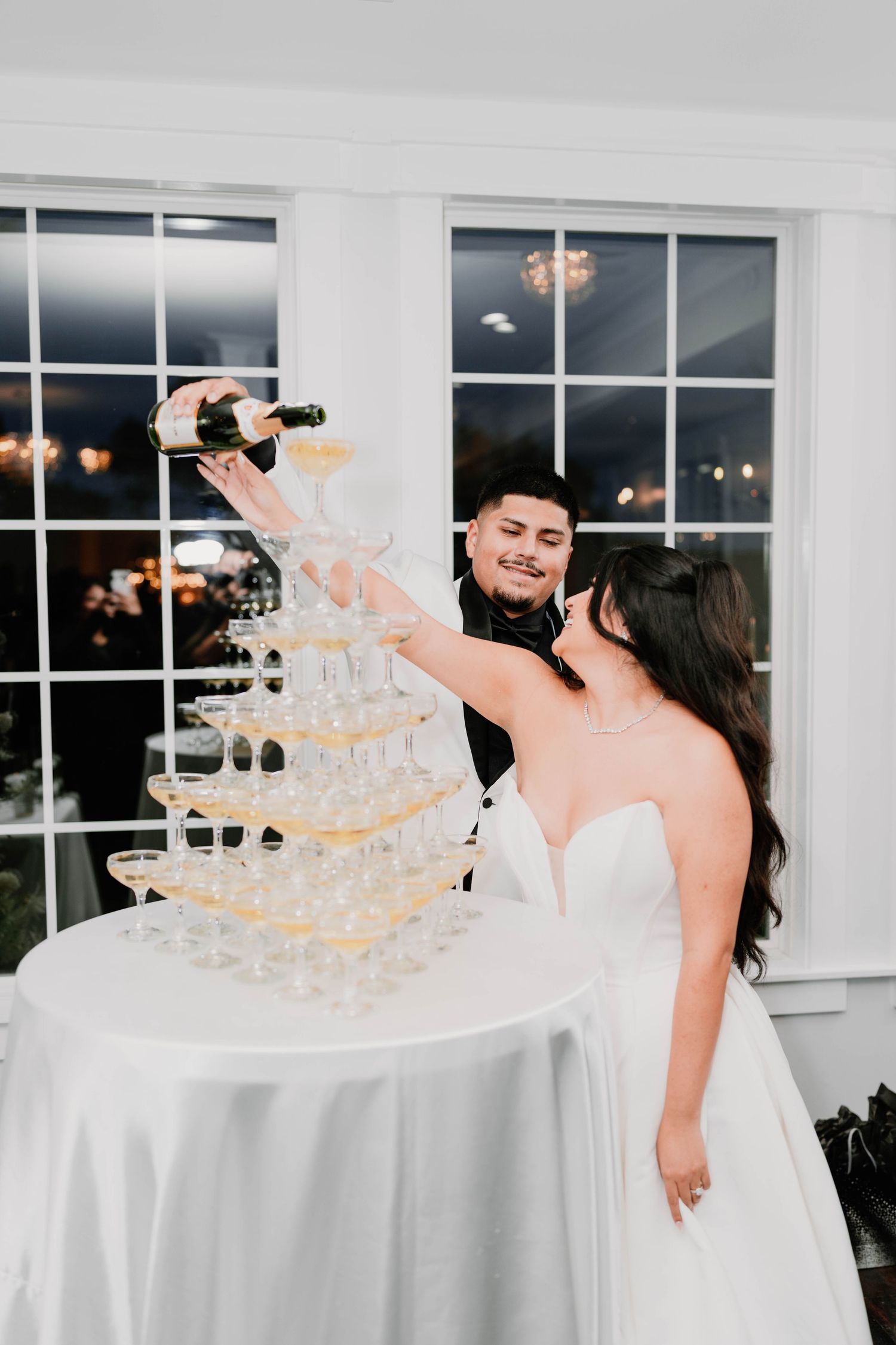 A champagne tower display with crystal glasses at an elegant wedding reception.