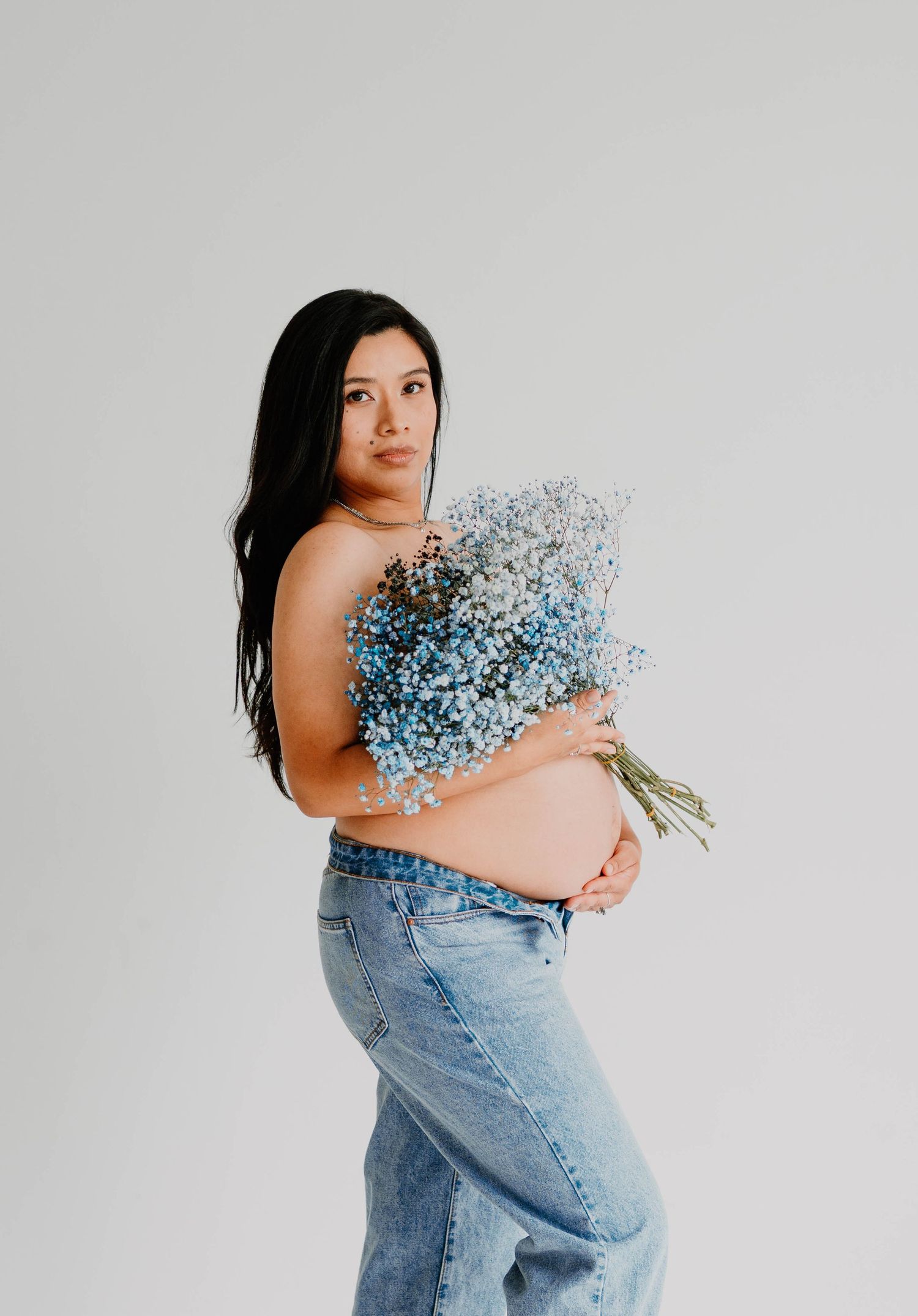 Studio portrait with blue baby's breath flowers and denim creating an artistic composition.