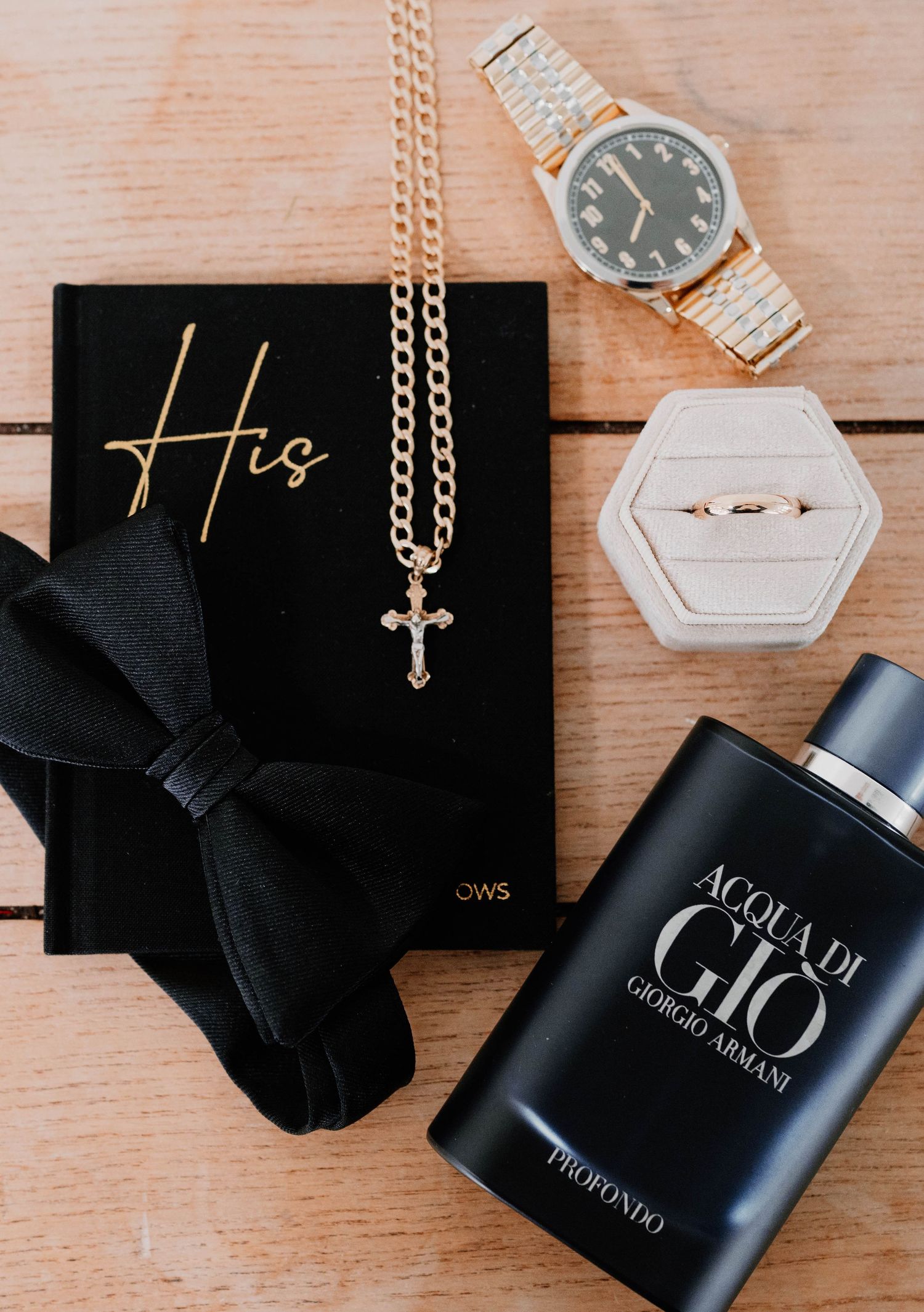 Wedding accessories including black ribbon, perfume bottle, and gold cross necklace.