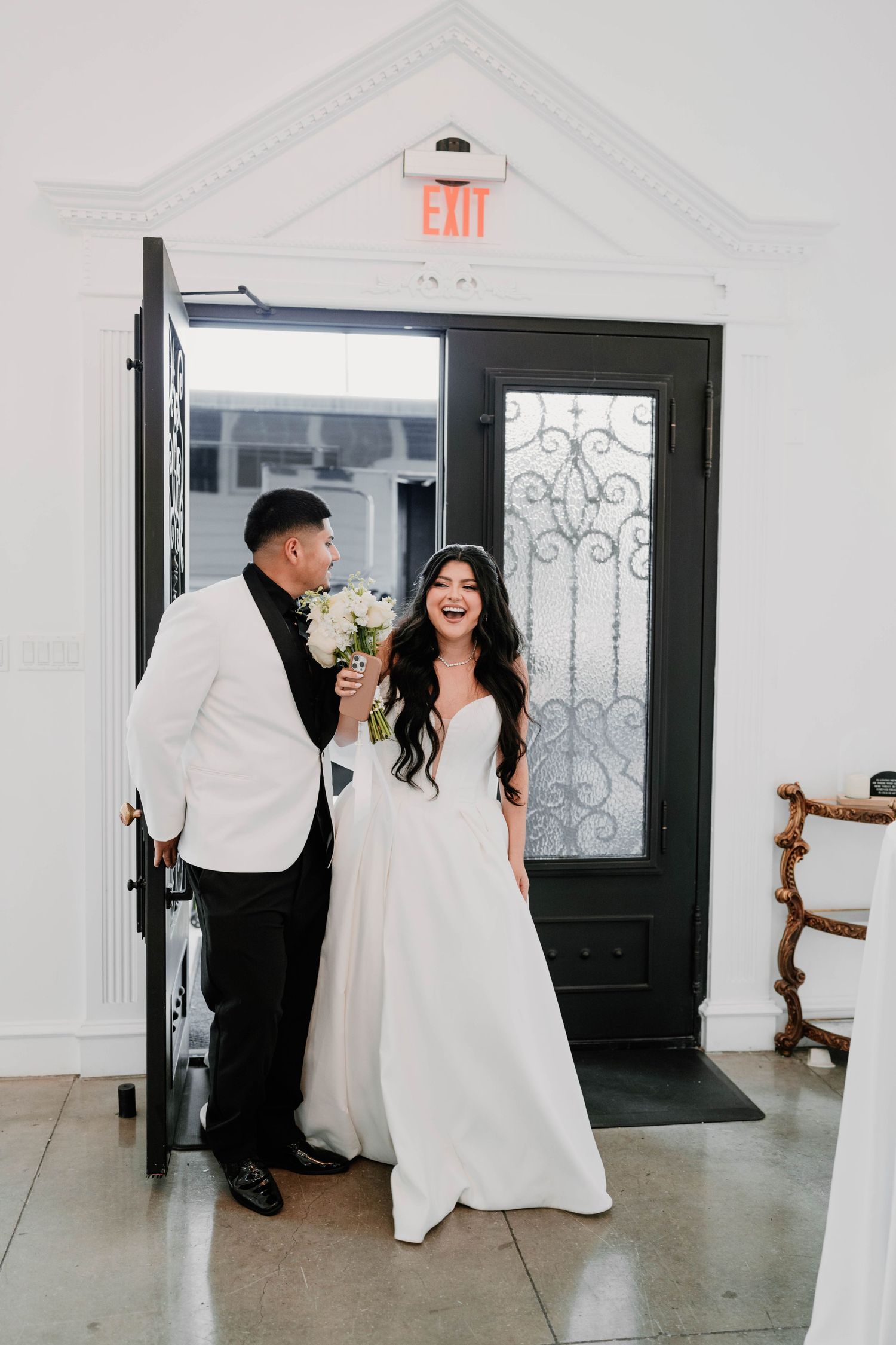 A candid first look moment between newlyweds in a bright white venue.