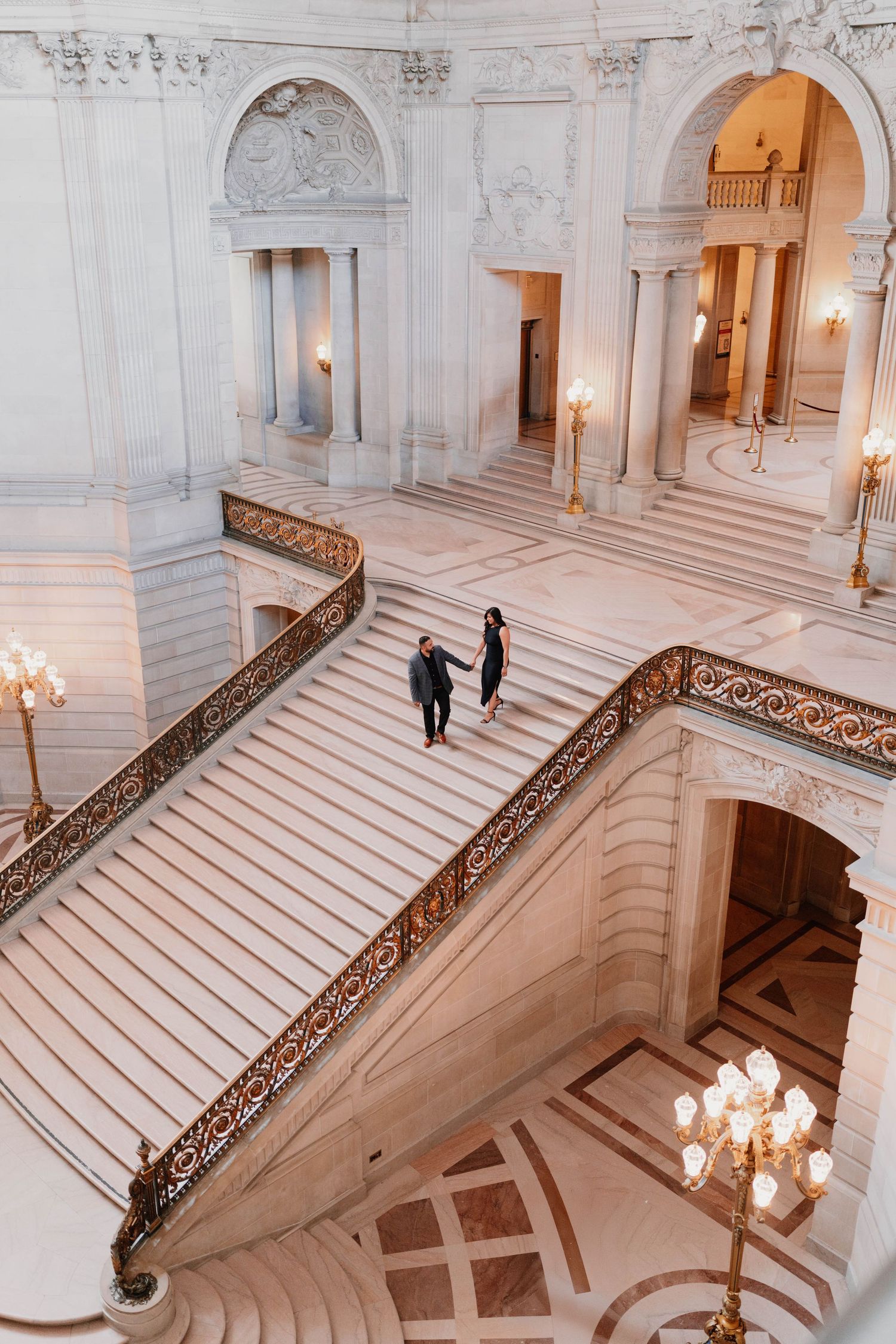 Grand marble staircase with ornate railings in an elegant classical building.