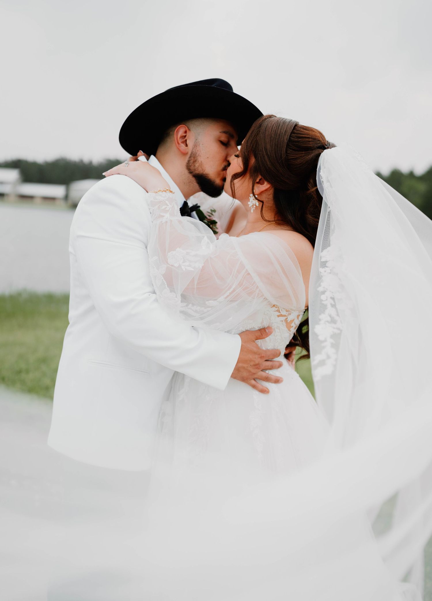 Romantic wedding photography with flowing white dress and veil in soft lighting.