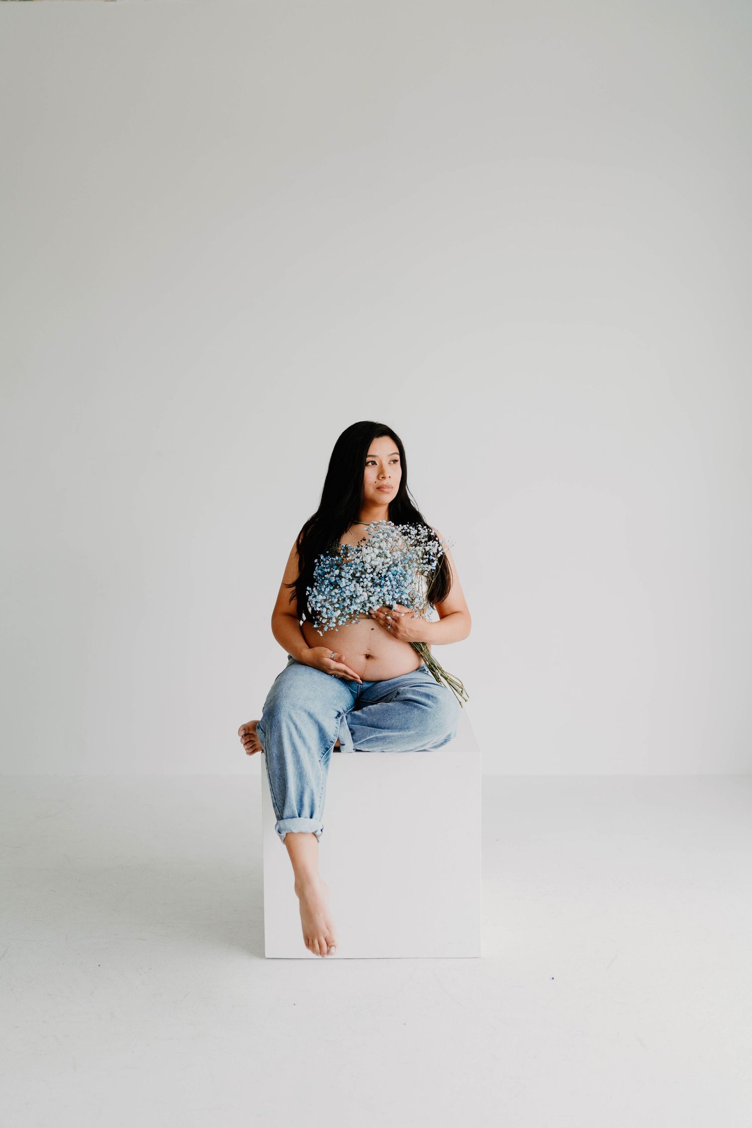 Minimalist studio photoshoot featuring denim and casual style against white background.
