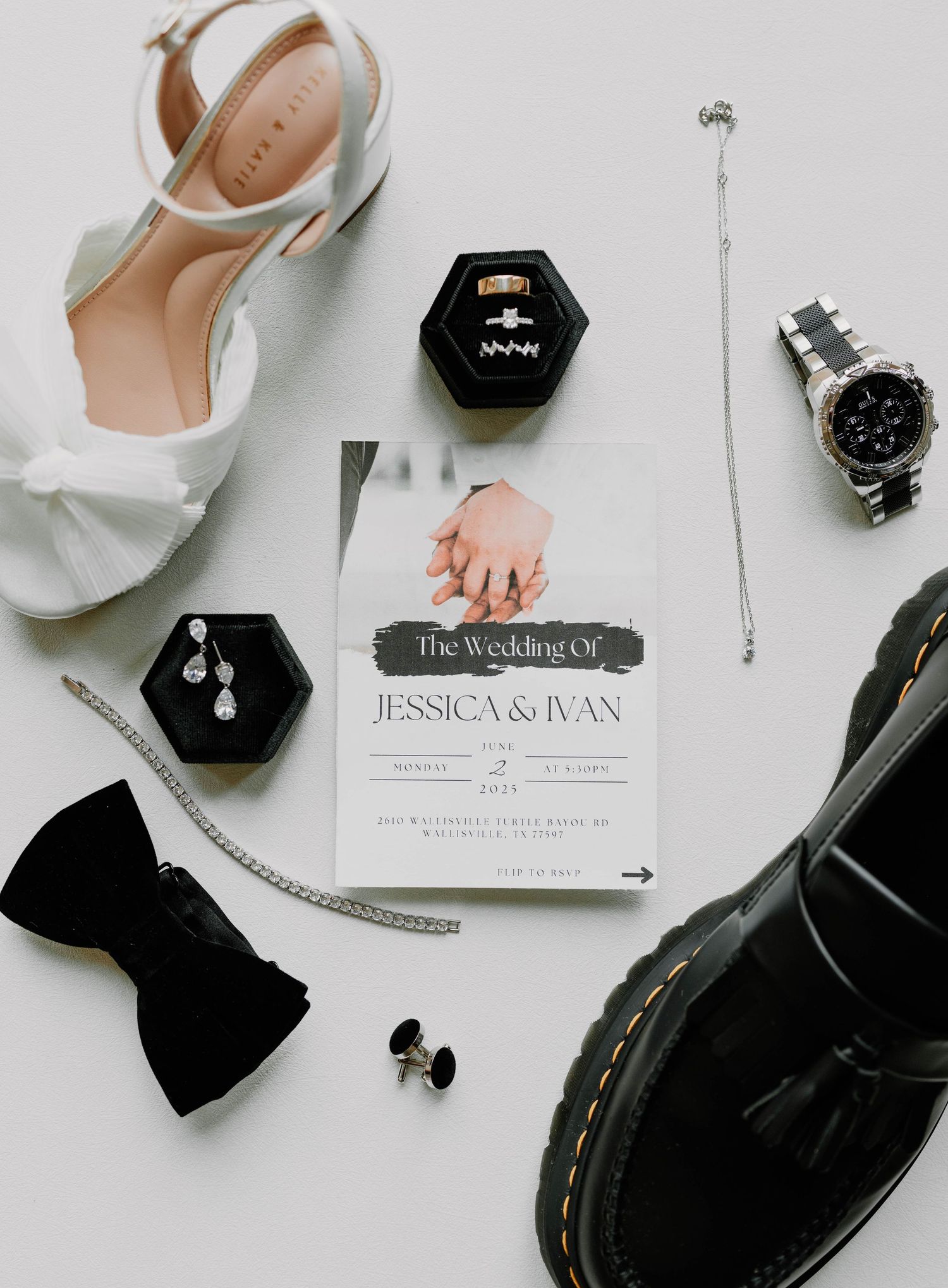 Wedding accessories including white shoes, rings, bow tie, and invitation arranged on grey background.