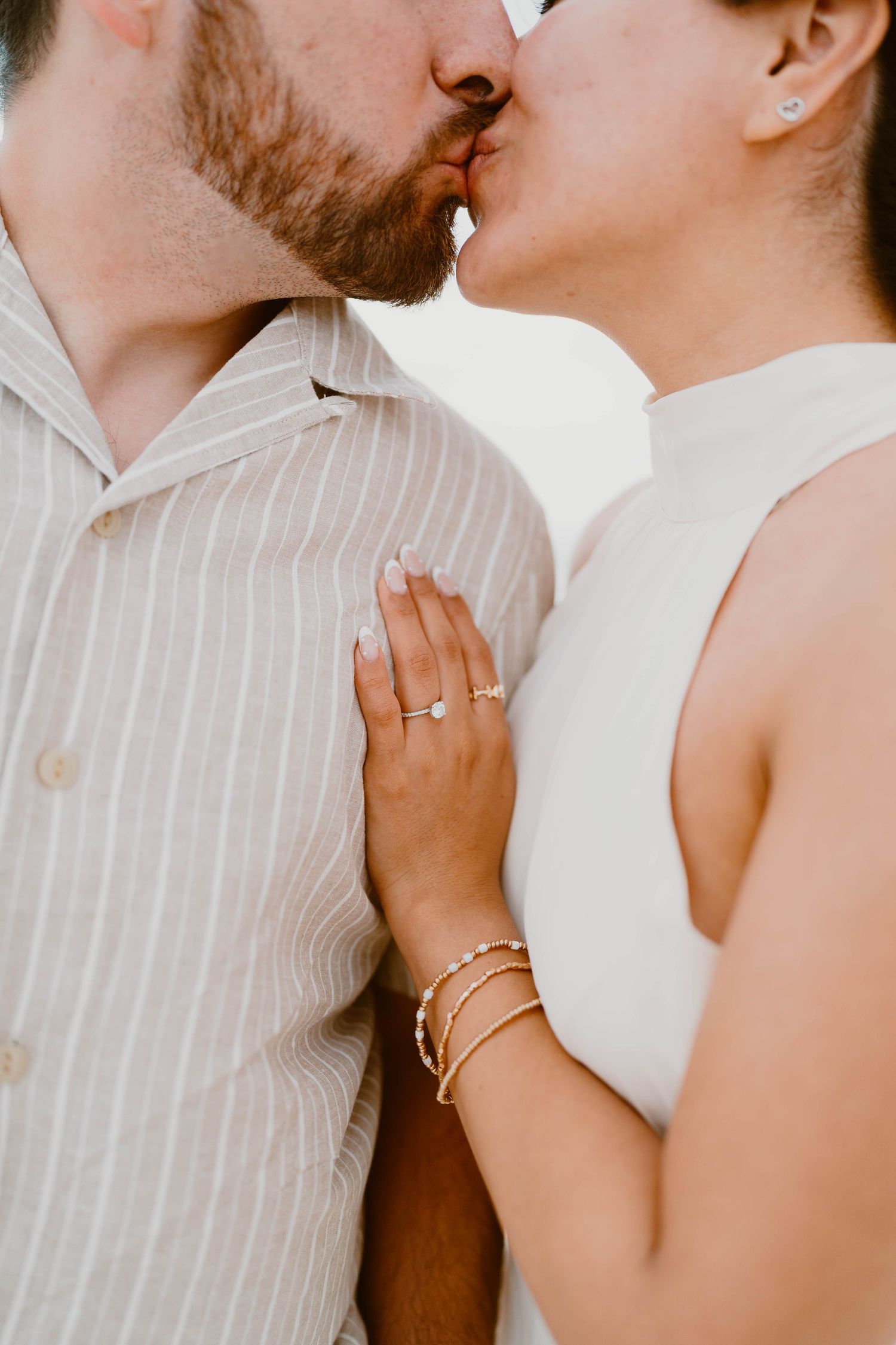 Close-up shots of intimate moments between couple showing engagement ring and tender embraces.