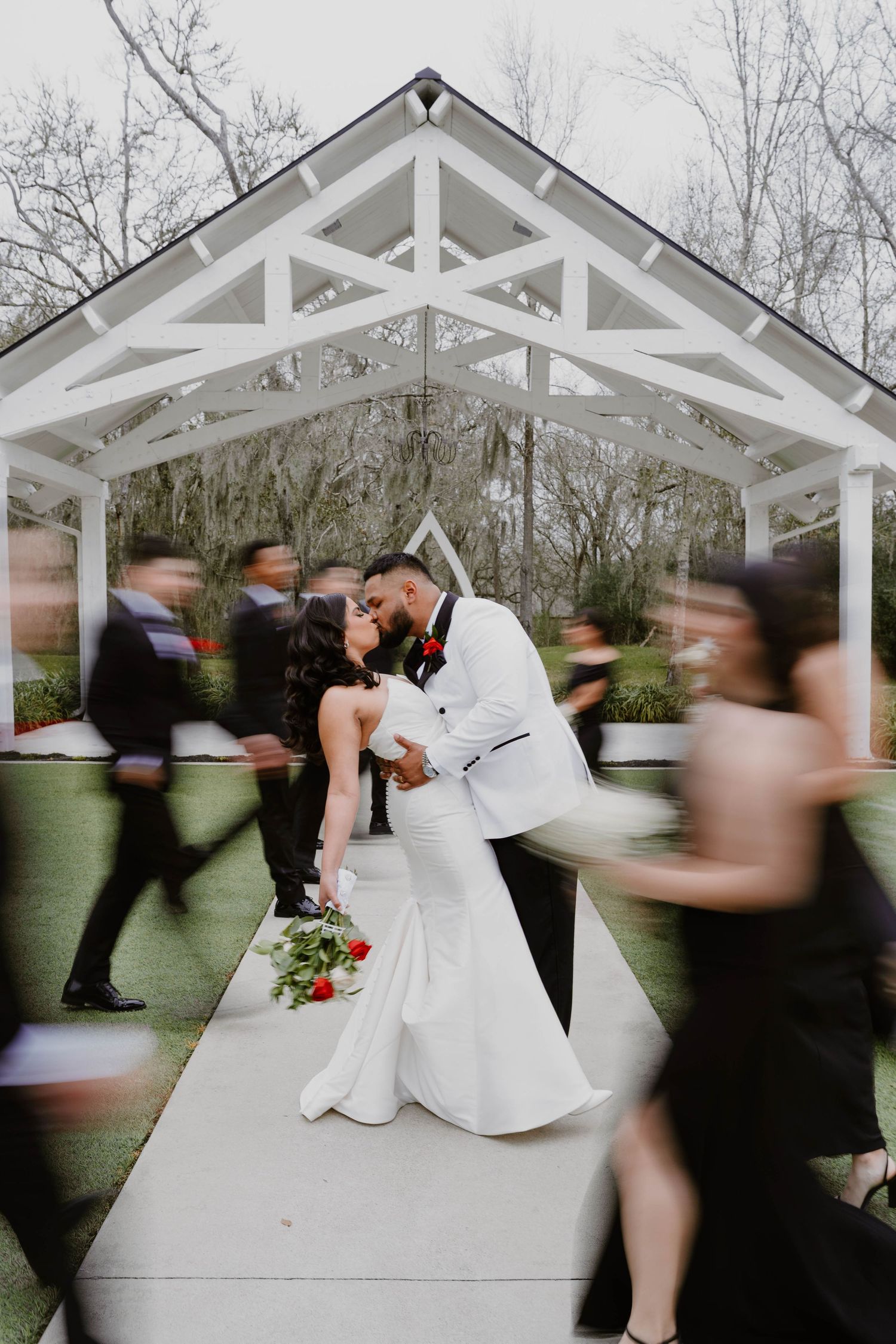 A series of motion blur wedding photos showing a couple dancing under a white outdoor pavilion.