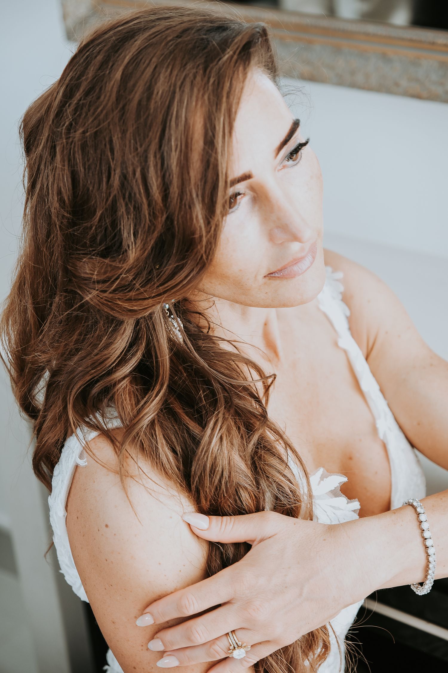 Bridal portrait with soft waves and delicate lace details.