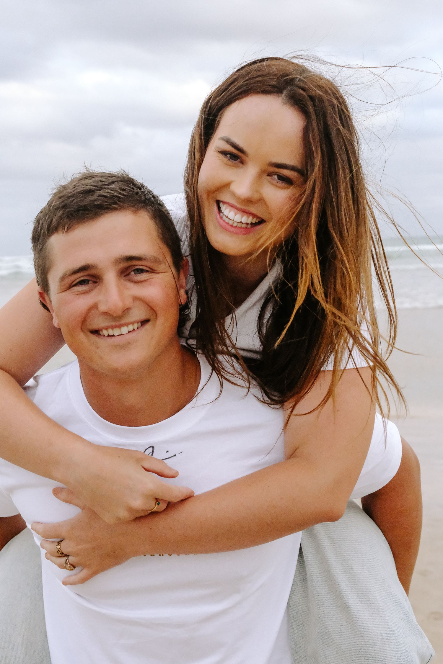 Happy couple sharing playful embrace at beach.