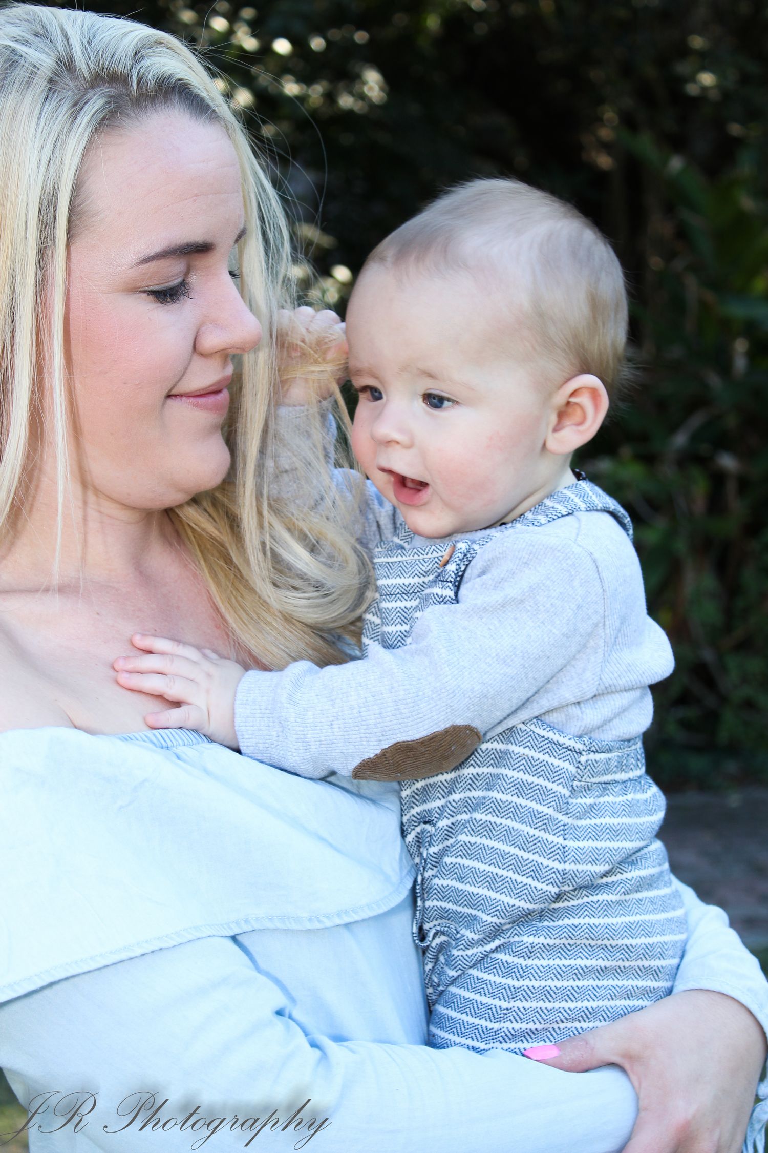 Parent and baby sharing a tender moment in outdoor portrait.