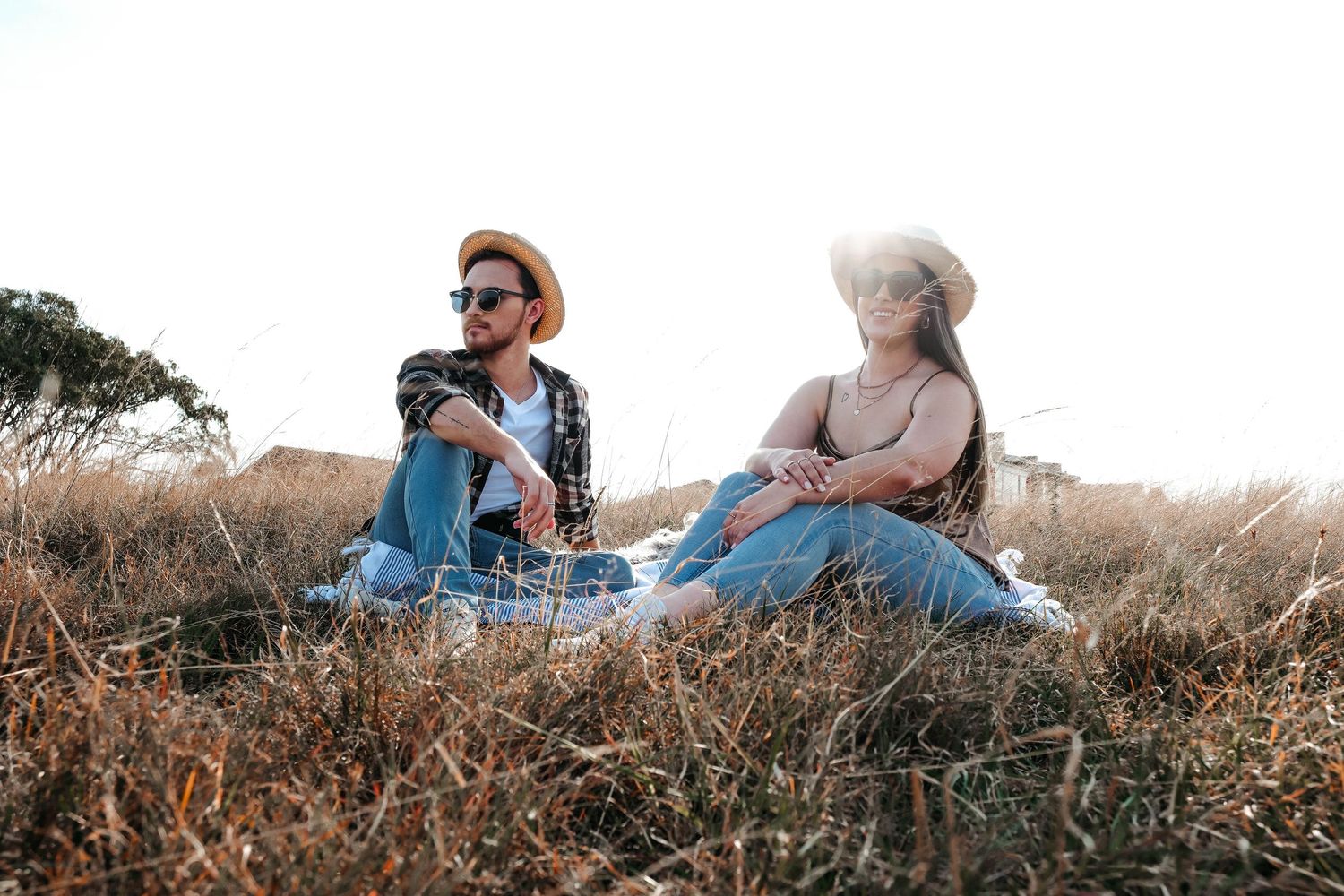 Two friends having a picnic on a hilltop during golden hour.
