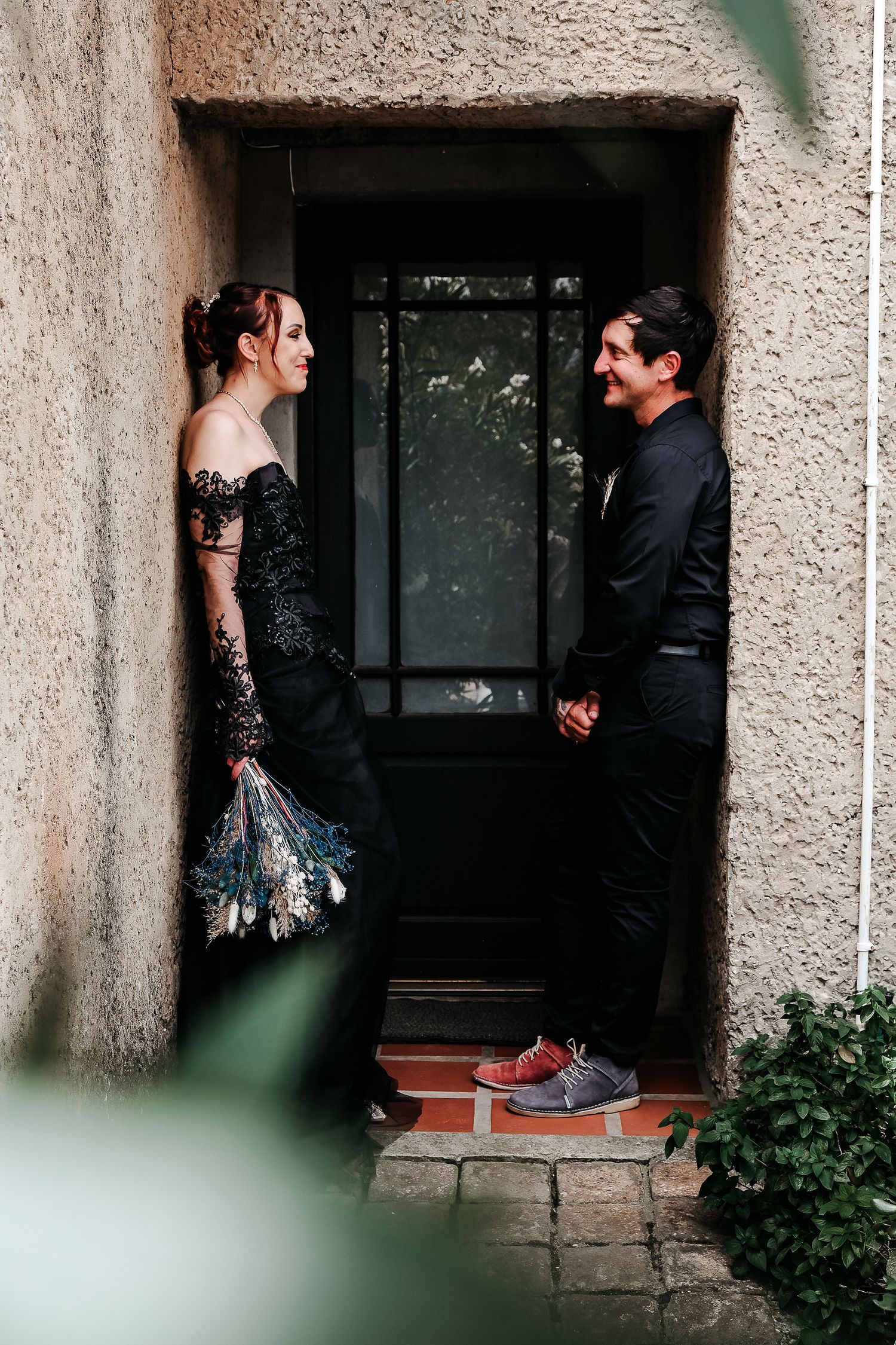 A couple in formal attire sharing a moment in a doorway.