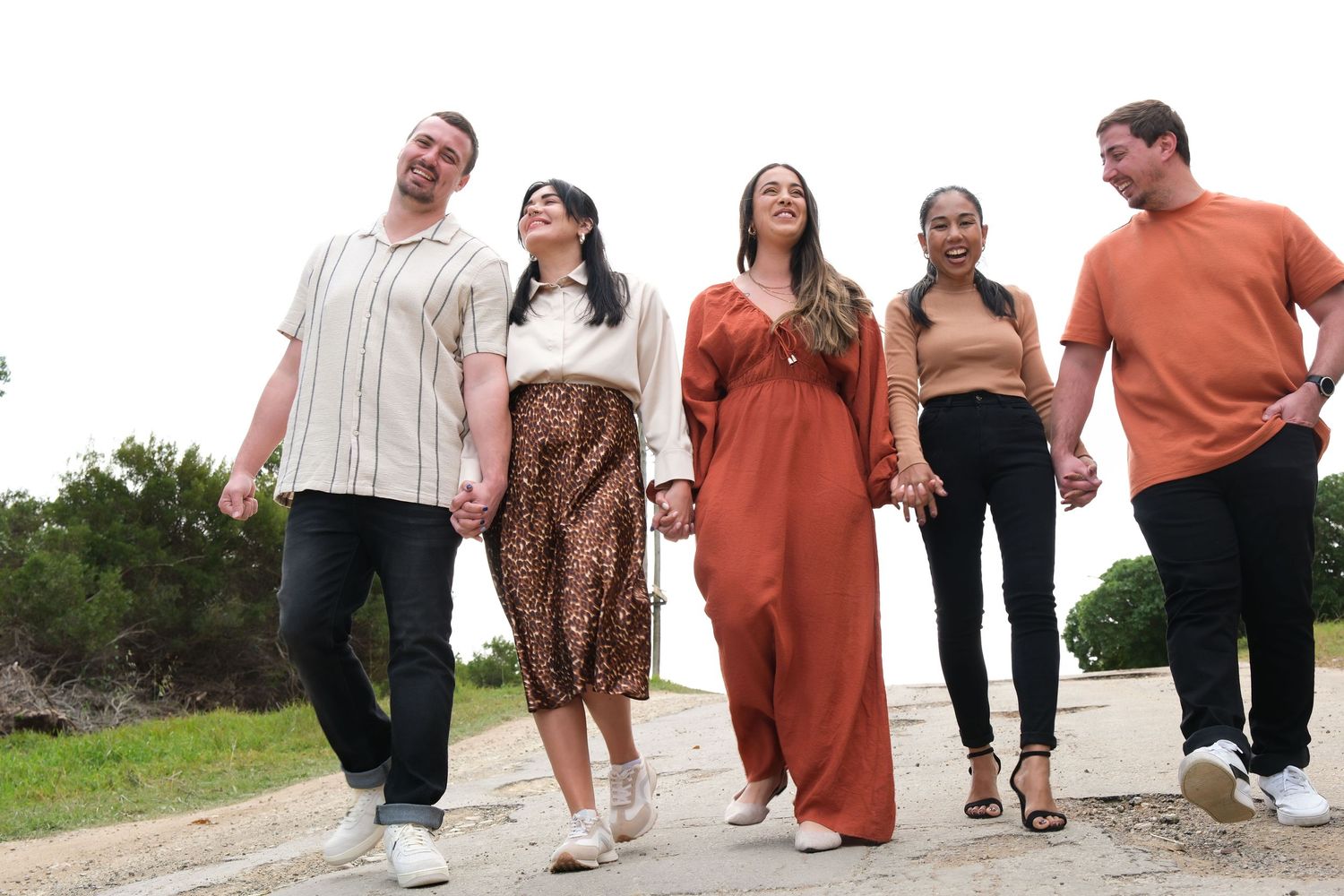 A group of friends walking together outdoors in casual attire.