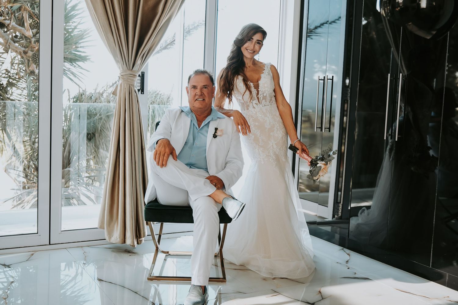 Wedding day portrait in bright modern space with floor-to-ceiling windows.