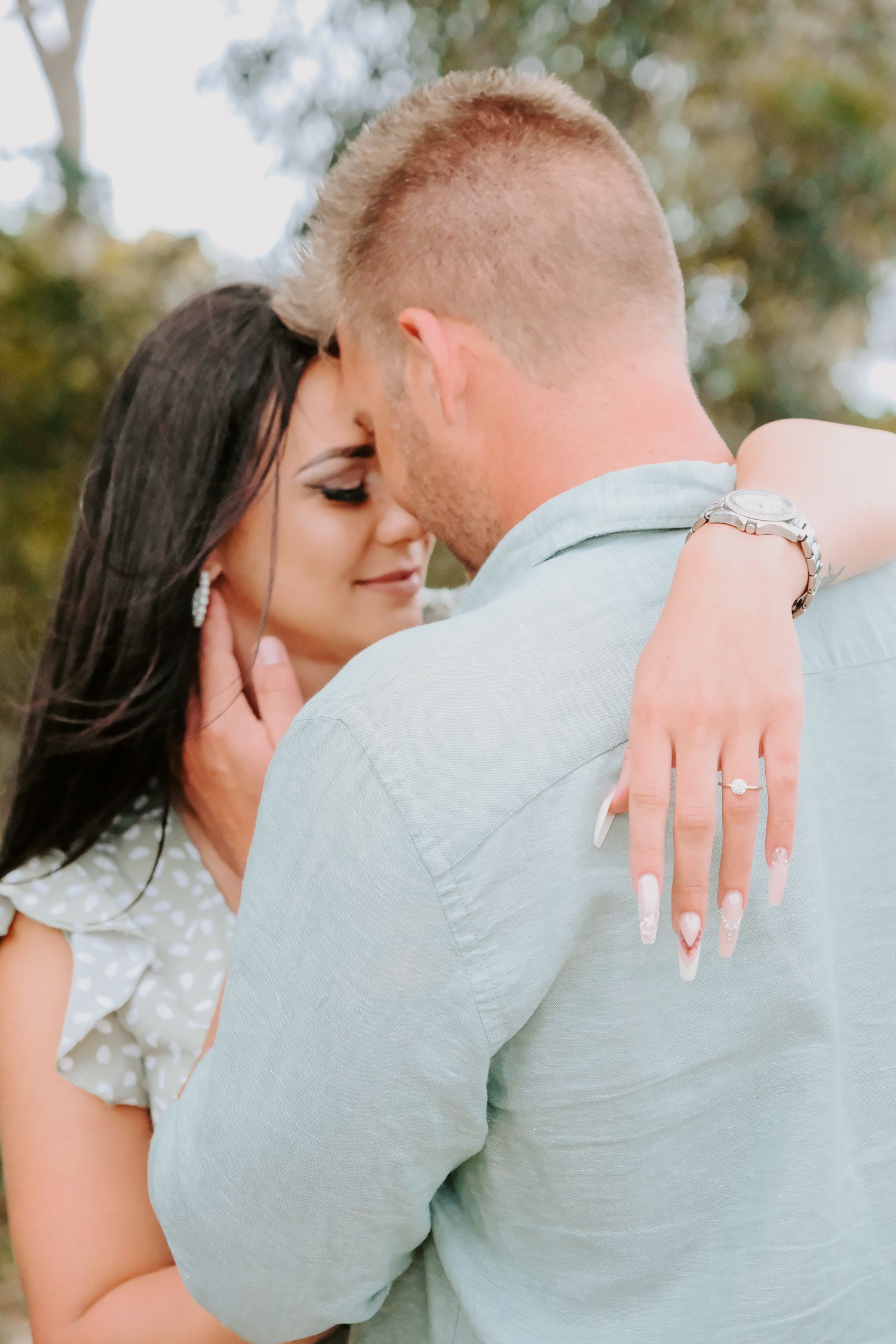 Close up of tender moment between couple with ring display.