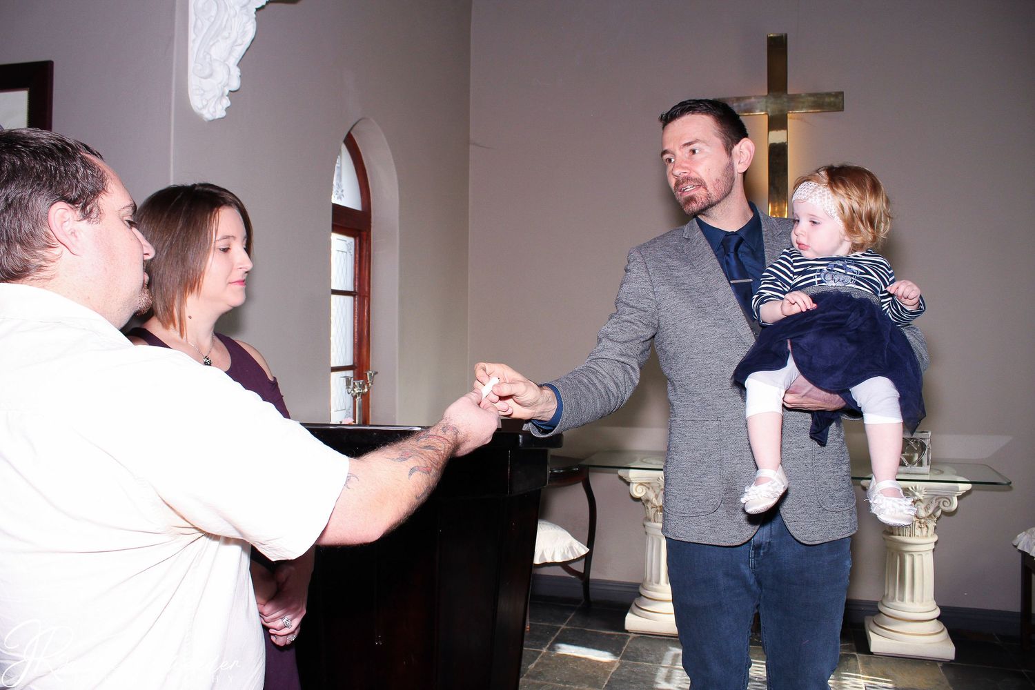 A joyful moment of celebration and laughter inside a church with arched windows and a white cross visible in the background.