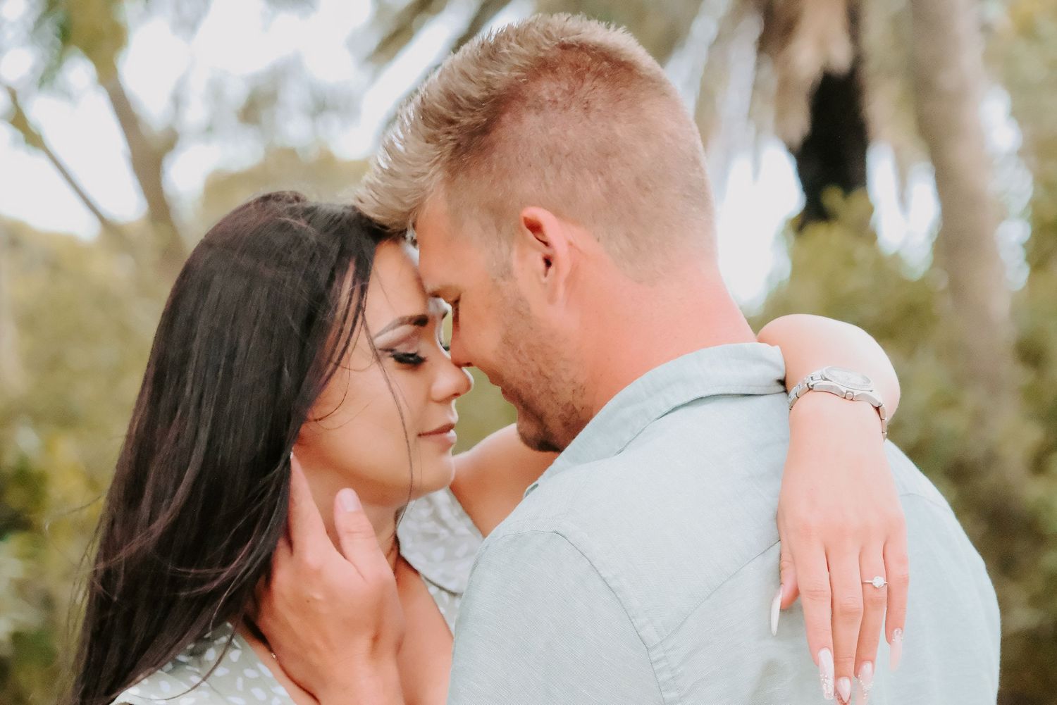 A tender romantic moment shared between a couple with foreheads touching.