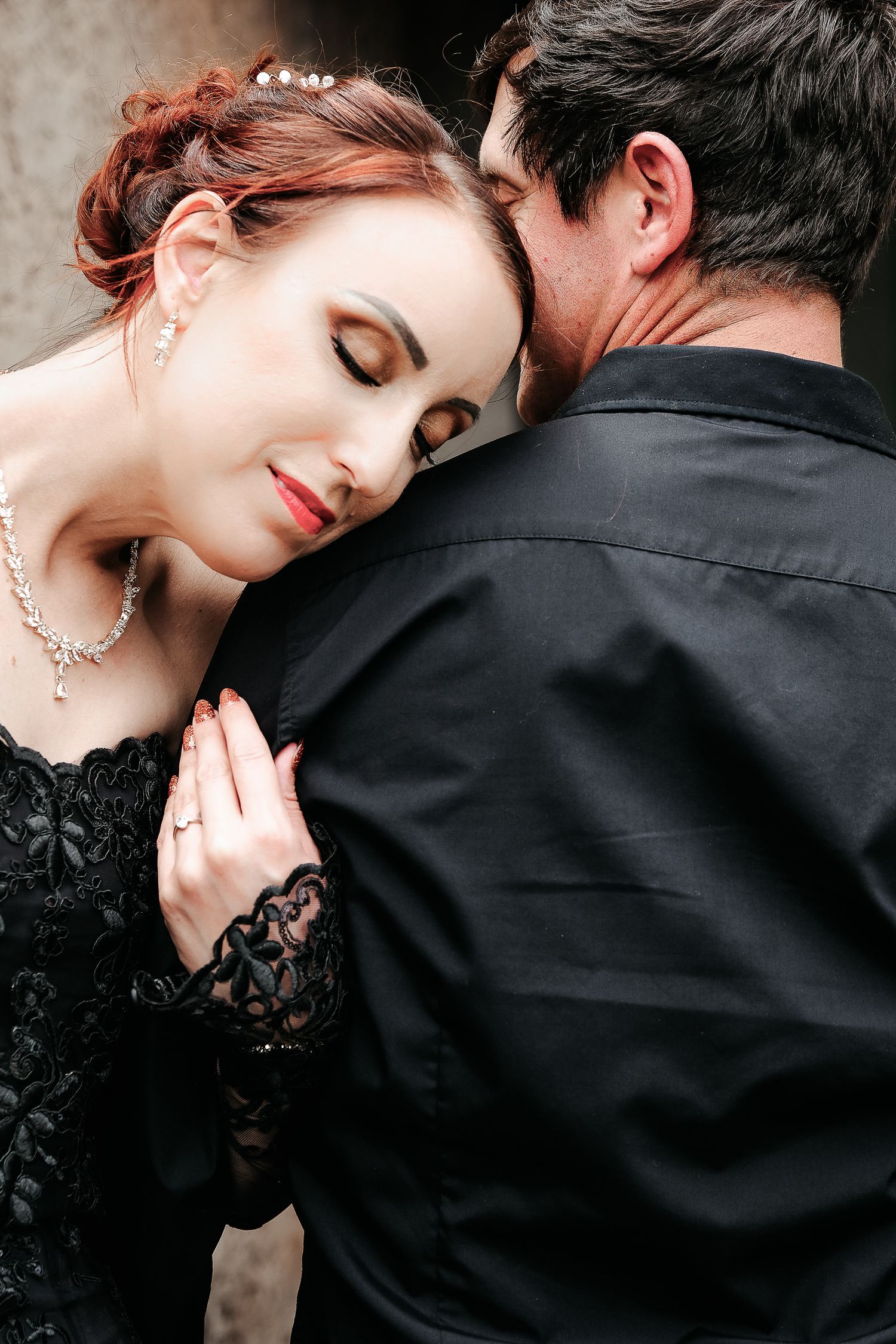 An intimate portrait of a couple in formal black attire.