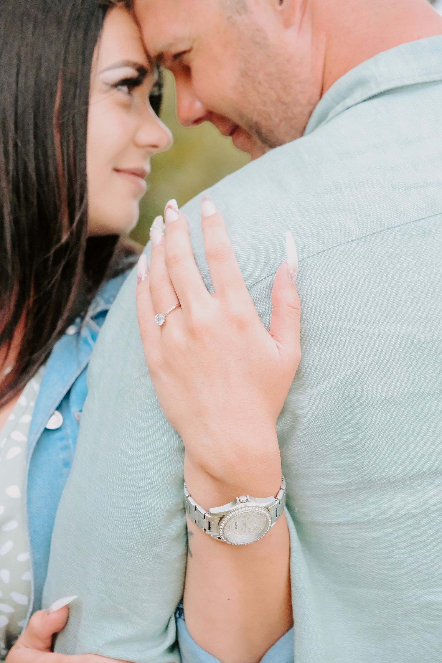 An intimate moment between a couple as she displays her new engagement ring.