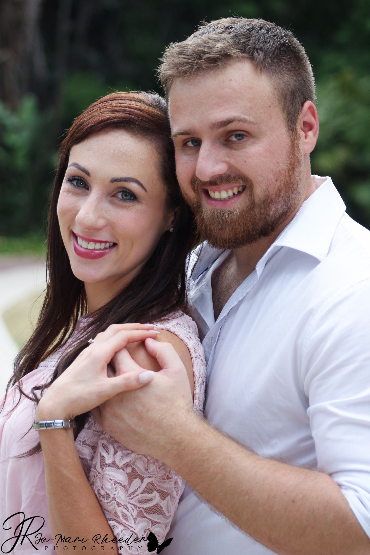 A romantic couple sharing an intimate moment while embracing outdoors in casual attire.