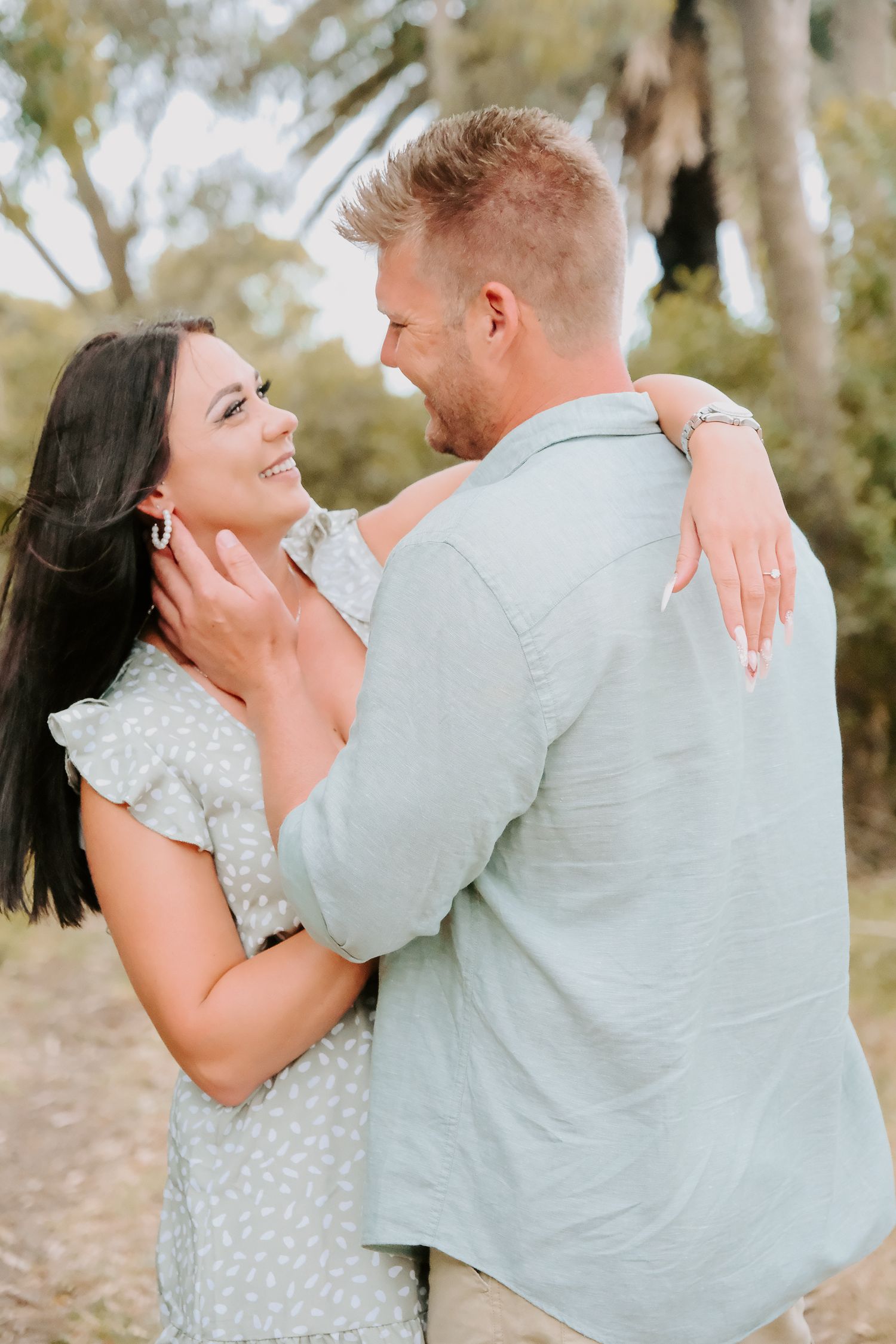 Intimate outdoor portrait showcasing new engagement ring.