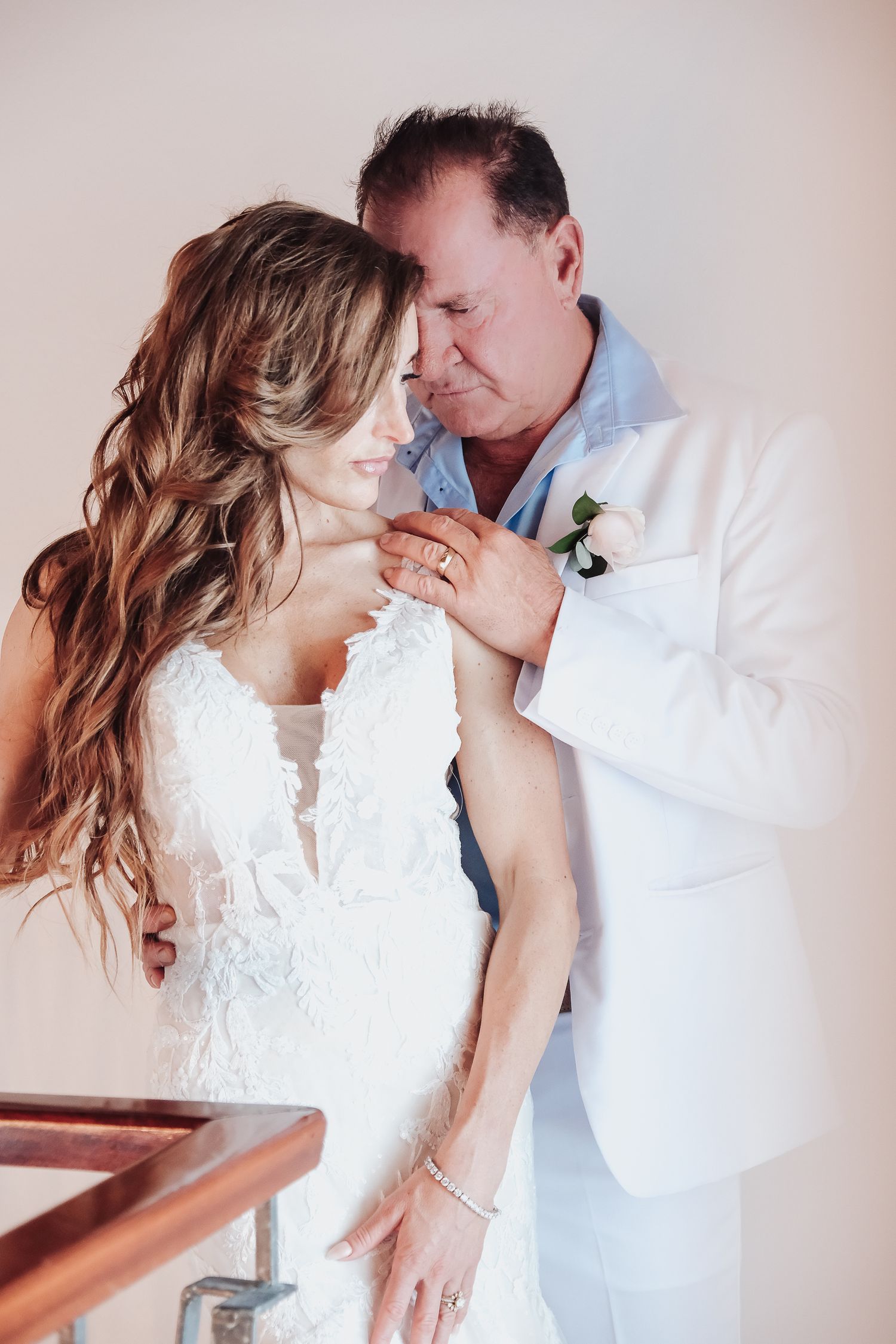 Intimate wedding portrait featuring white attire and tender embrace.