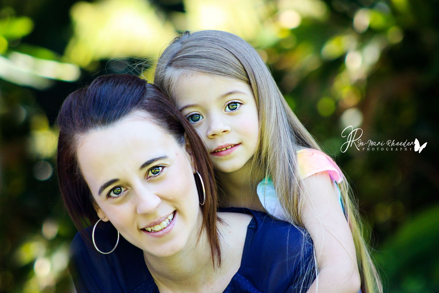 Close-up portrait in natural lighting with green foliage background.
