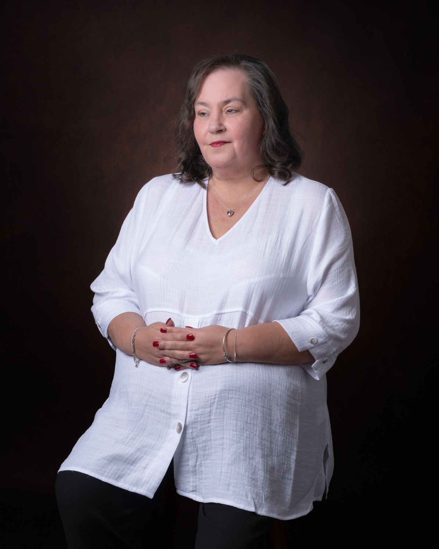 A series of studio portraits featuring someone in a white blouse against a dark background.