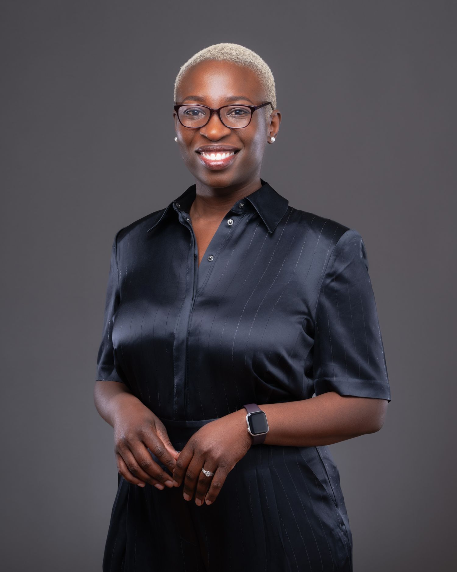 Professional portrait series of a person in a black button-down shirt against a gray studio background showing various poses.