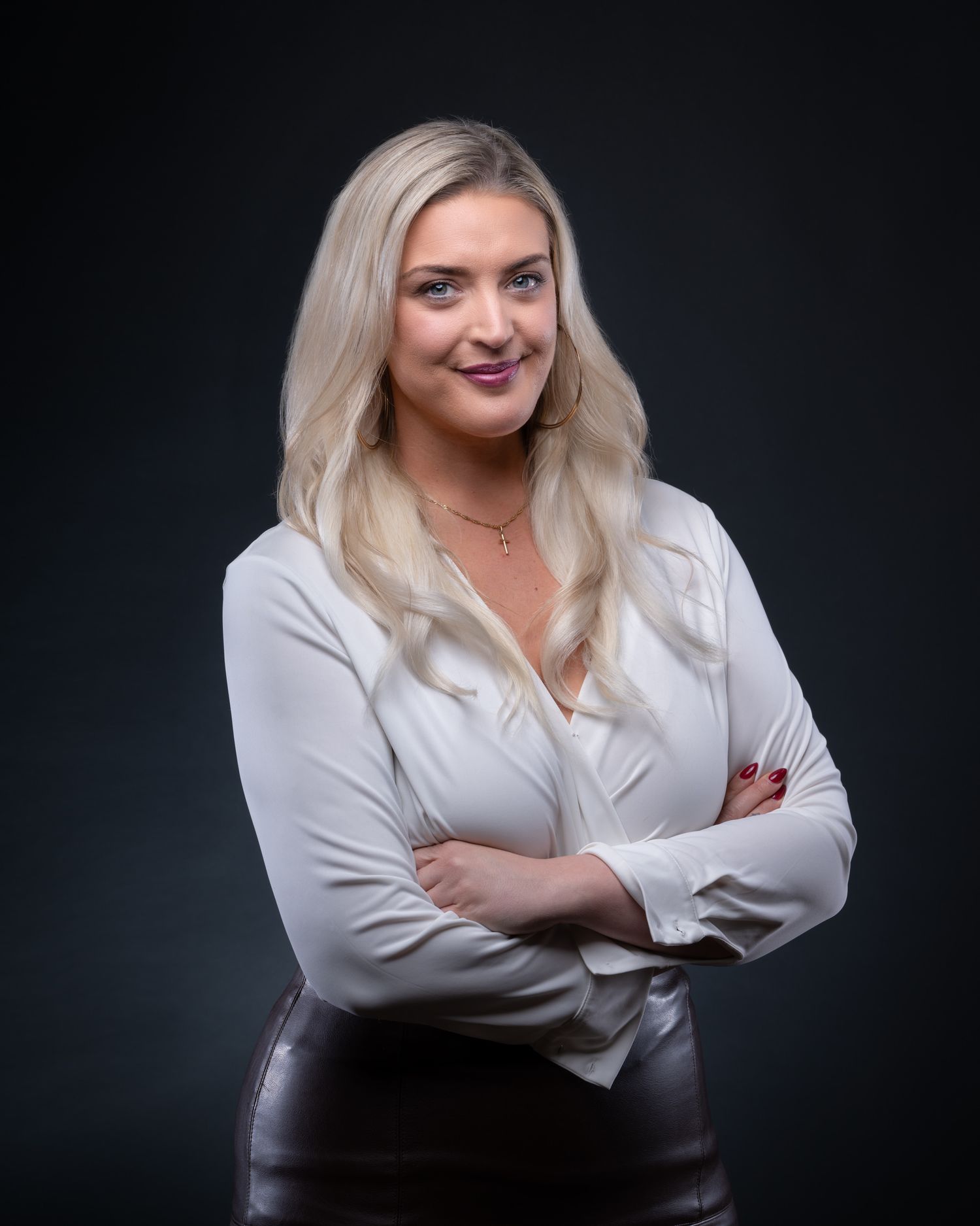 Professional studio portraits on dark background showcase blonde woman in white blouse posing confidently.