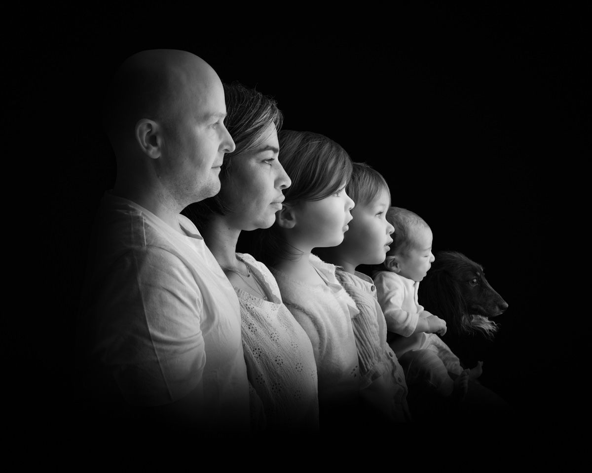 Black and white artistic portrait showing silhouettes of people in profile against dark background.